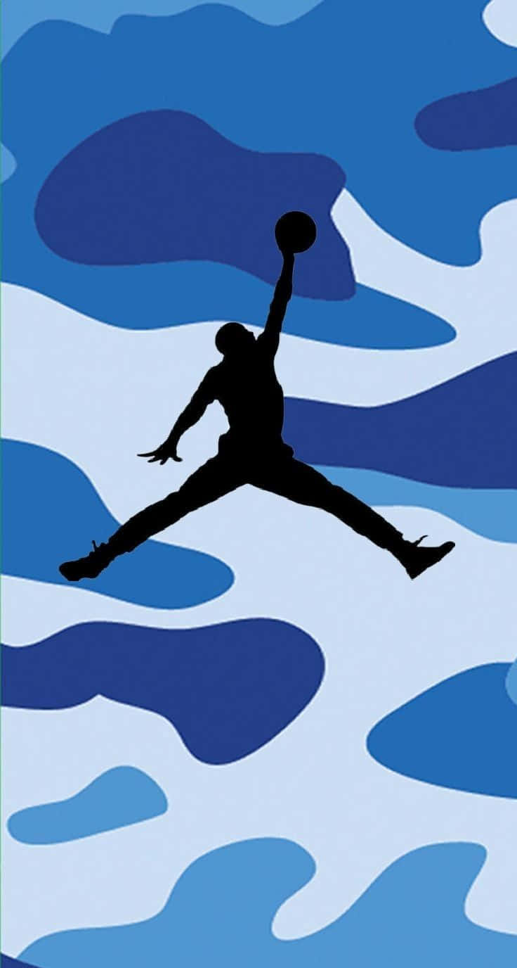 Air Jordan 桌布 壁紙 — 一個黑色剪影的籃球運動員在半空中灌籃，背景是藍白迷彩圖案。
