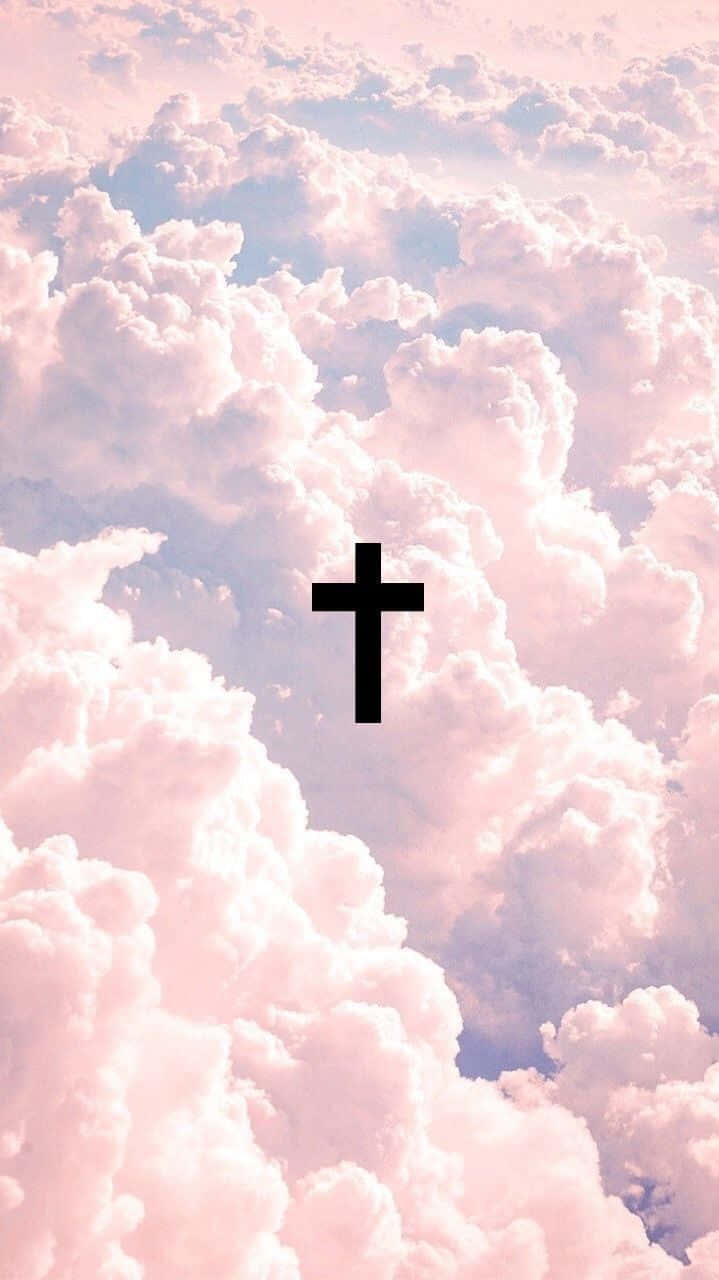 Cute Cross 桌布 壁紙 — 一個黑色十字架在充滿蓬鬆雲朵的柔和粉紅色和藍色天空中寧靜地漂浮。