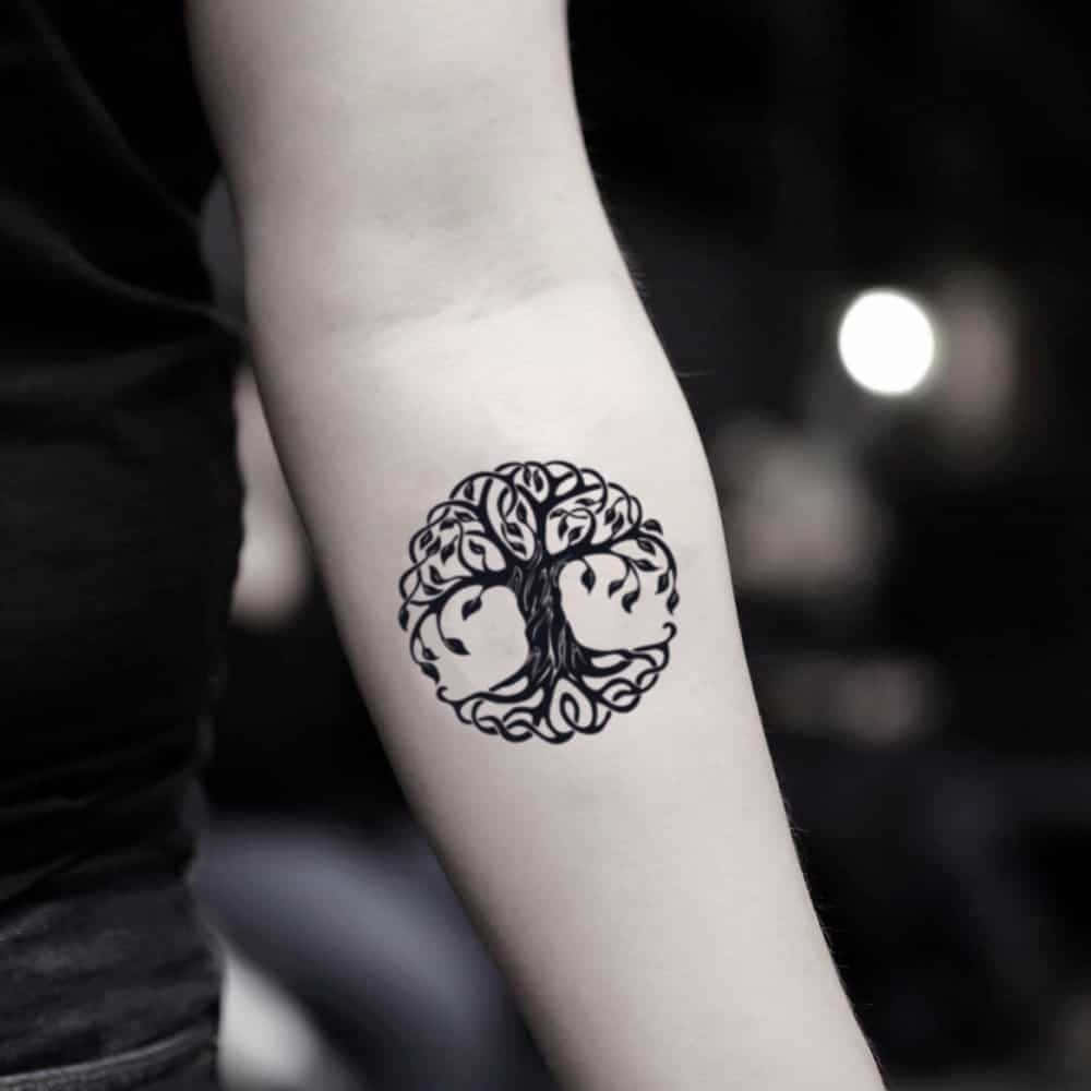 Tree Of Life 桌布 壁紙 — 一個黑色墨水的生命之樹紋身，精細地紋在一個人的前臂內側，背景光線柔和模糊。