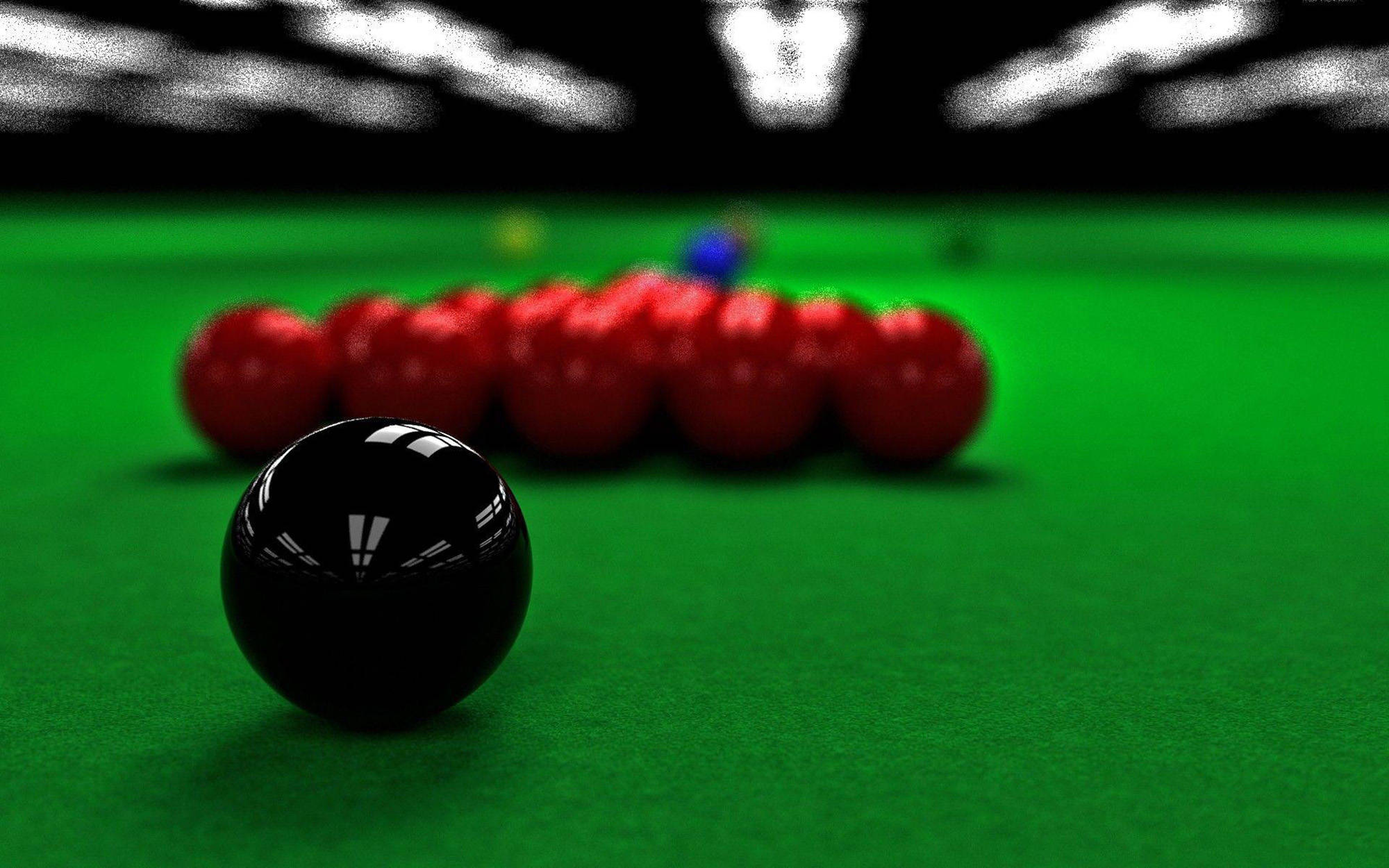 Snooker 桌布 壁紙 — 一個黑色撞球球的特寫，在綠色絨布桌上清晰對焦，背景有紅色球模糊。
