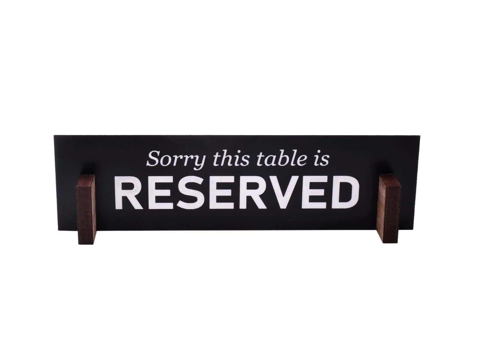 Reserved 桌布 壁紙 — 一個黑色木牌，上面有白色文字寫著「Sorry this table is RESERVED」，立於兩條深色木腿上，背景為純白色。