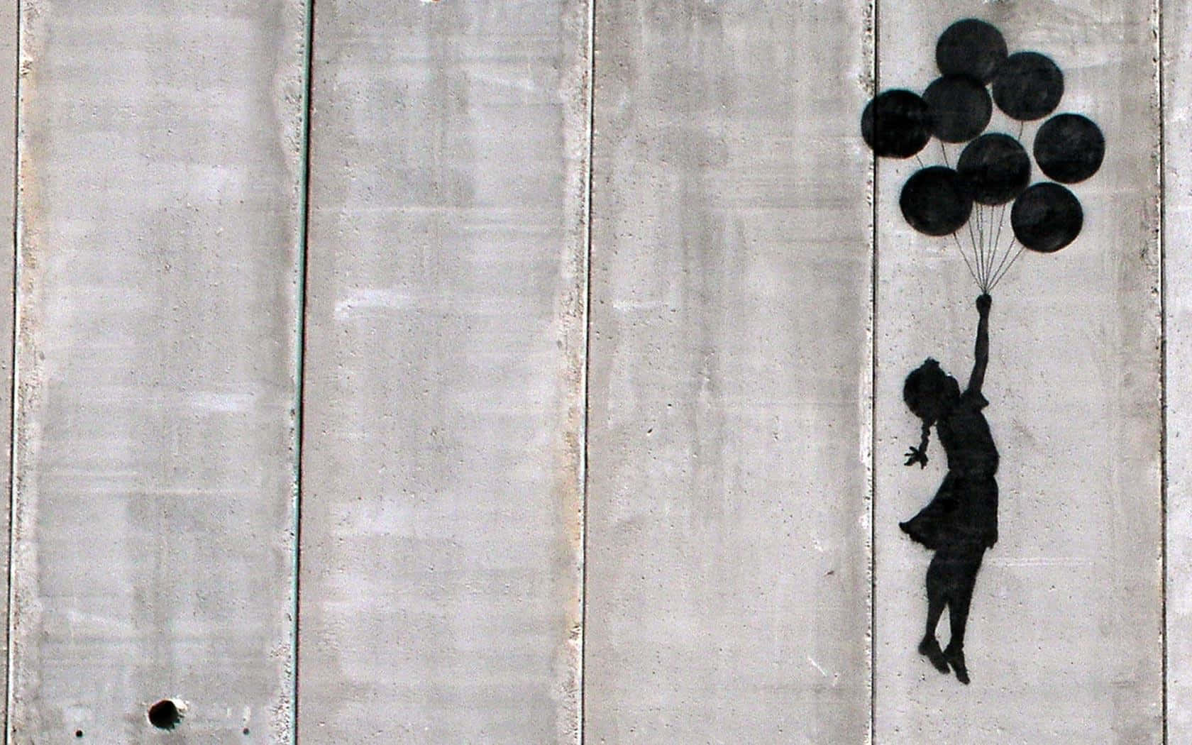 Banksy 桌布 壁紙 — 一個黑色模板，描繪一個拿著氣球的女孩，浮現在風化的混凝土牆上。