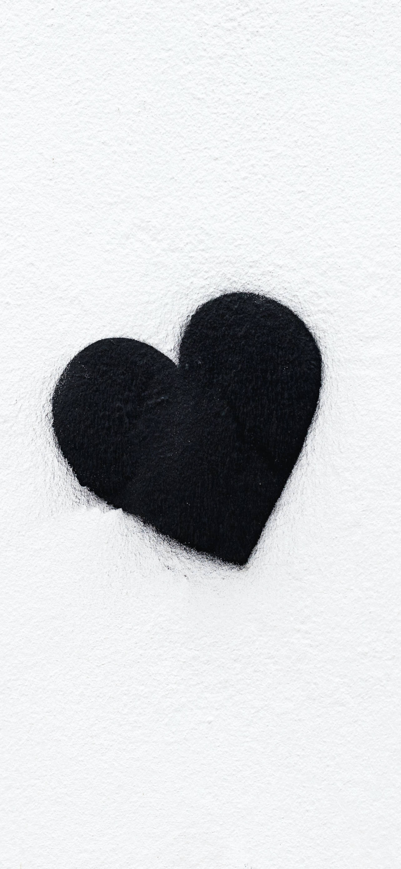 Black Heart Aesthetic 桌布 壁紙 — 一個黑色氈心放在有紋理的白色表面上，帶有柔和陰影。