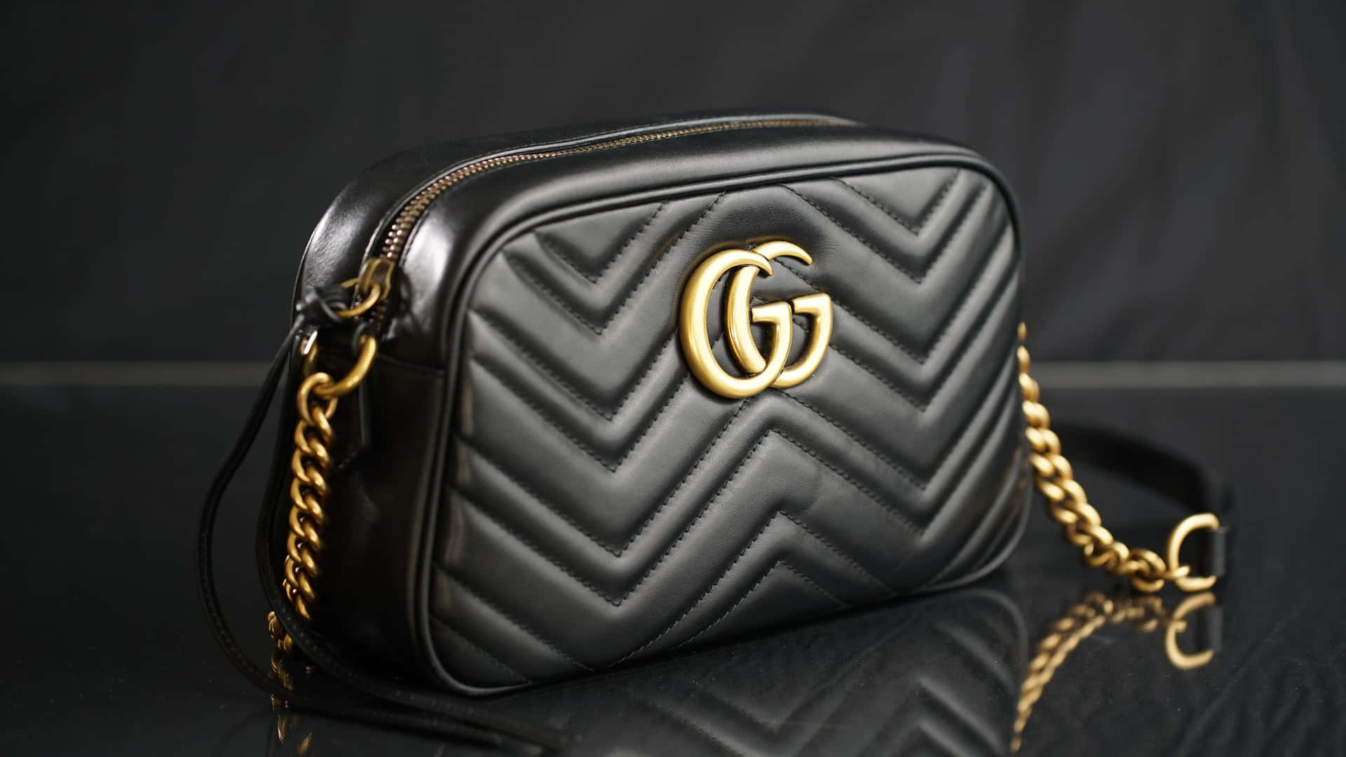 黑色絎縫Gucci手提包，金色鏈條肩帶，反射表面。 — Gucci GIF 壁紙