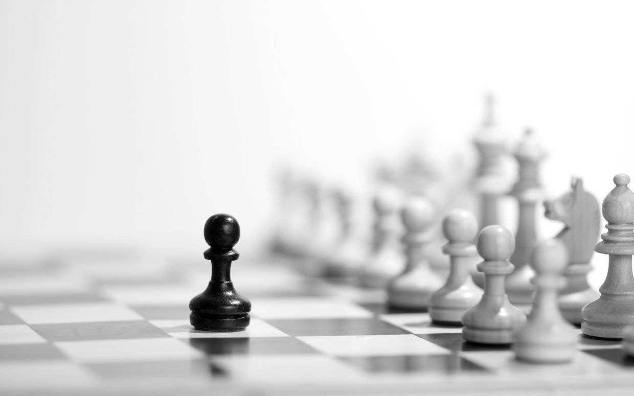 西洋棋 桌布 壁紙 — 一個黑色西洋棋兵卒在棋盤上清晰對焦，背景中模糊的白色棋子軍隊排列成行。
