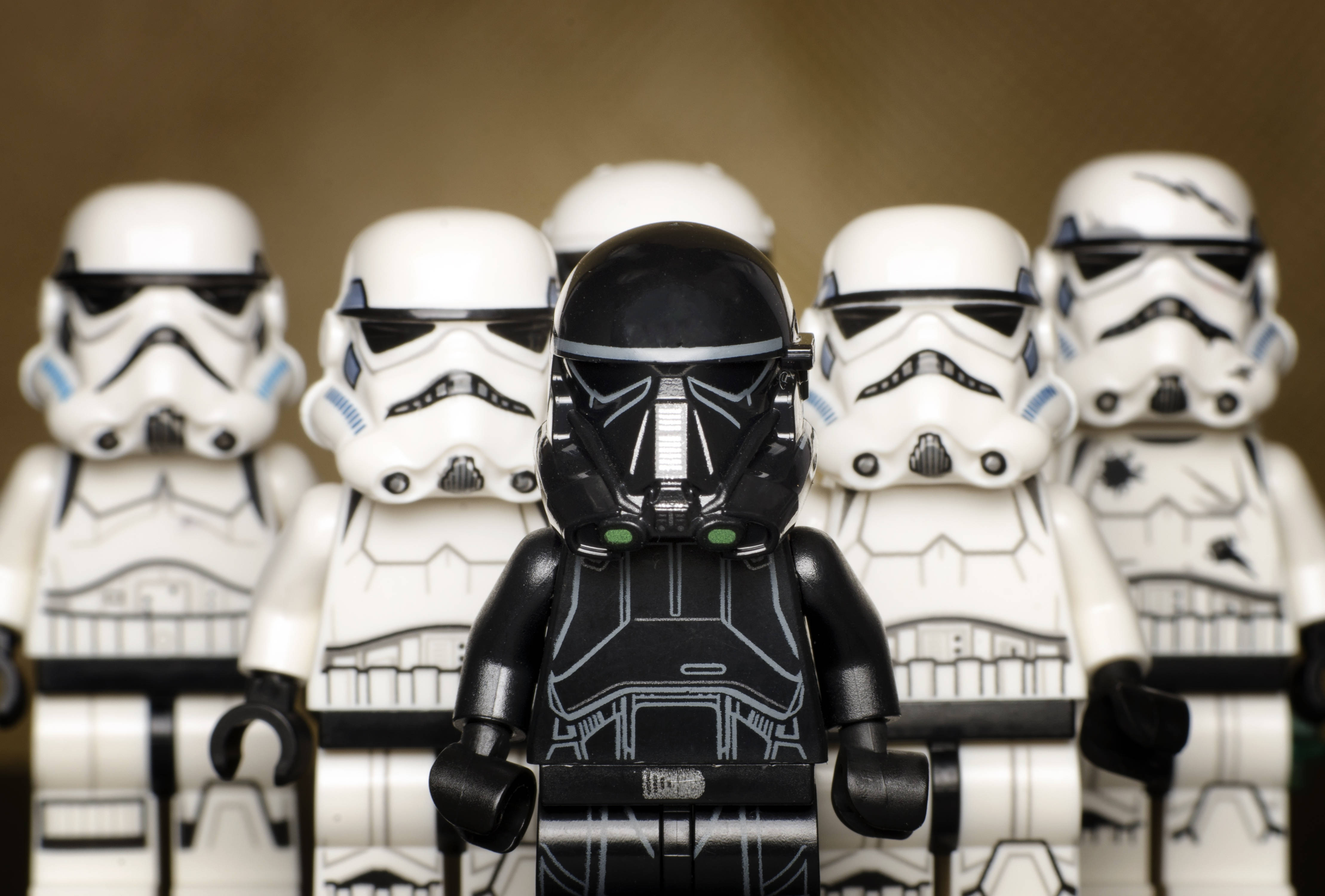 星際大戰 桌布 壁紙 — 一個黑色風暴兵LEGO迷你人偶站在正中央，兩側有白色風暴兵，景深較淺。