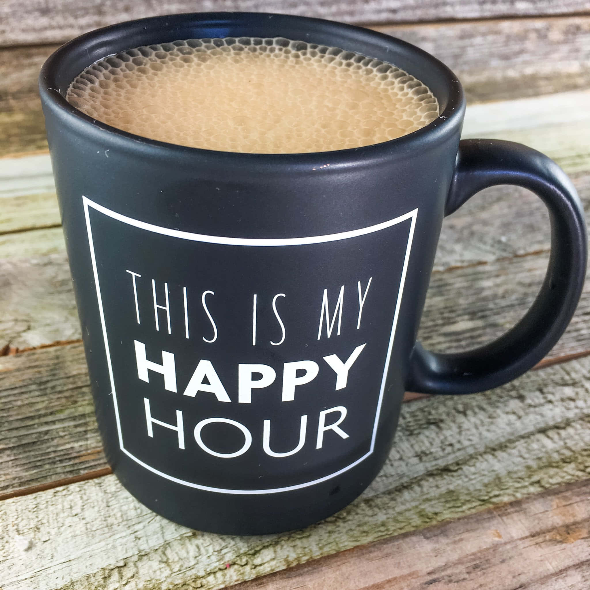Coffee Cup 桌布 壁紙 — 一個黑色馬克杯上印有白色文字 'THIS IS MY HAPPY HOUR'，放在充滿泡沫飲料的風化木板上。
