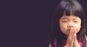 Praying 桌布 壁紙 — 一個黑髮年輕女孩閉上眼睛，雙手合十，在深色背景前做出溫柔的祈禱姿勢。