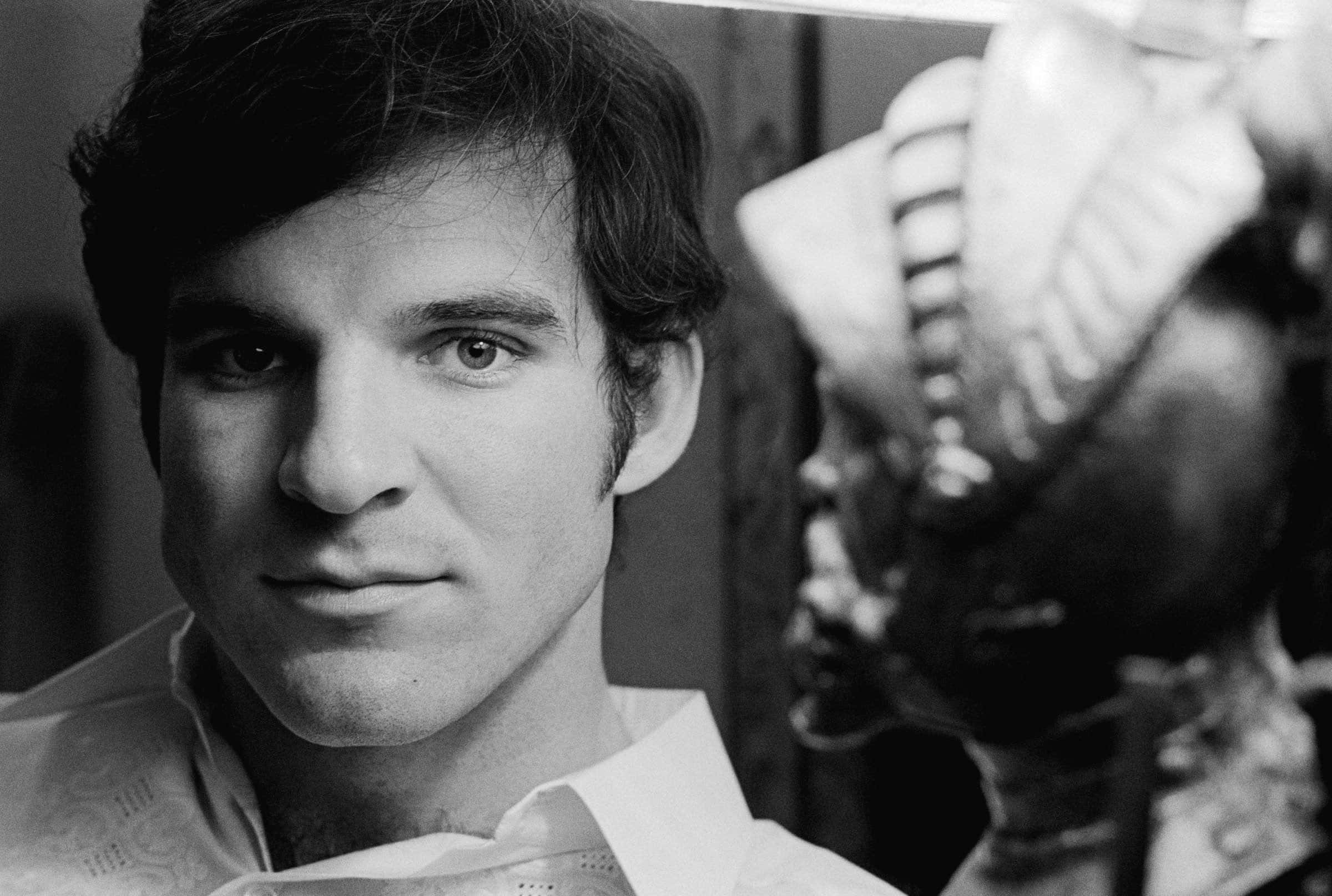 steve martin 桌布 壁紙 — 一個黑髮男士的黑白肖像，直視鏡頭，背景中有一個模糊的雕塑。