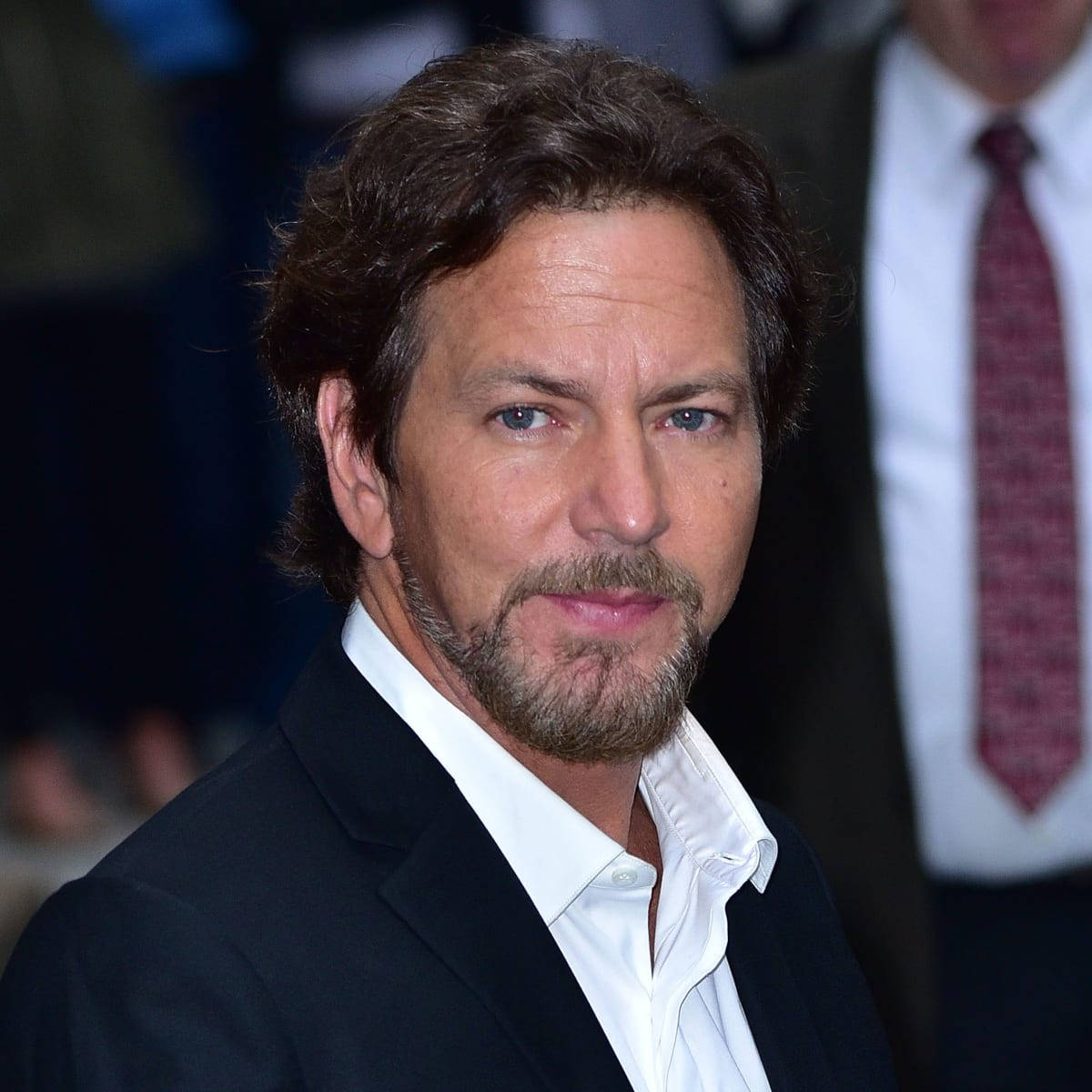 pearl jam 桌布 壁紙 — 一個黑髮鬍鬚男士穿著黑色西裝和白色襯衫的特寫肖像。