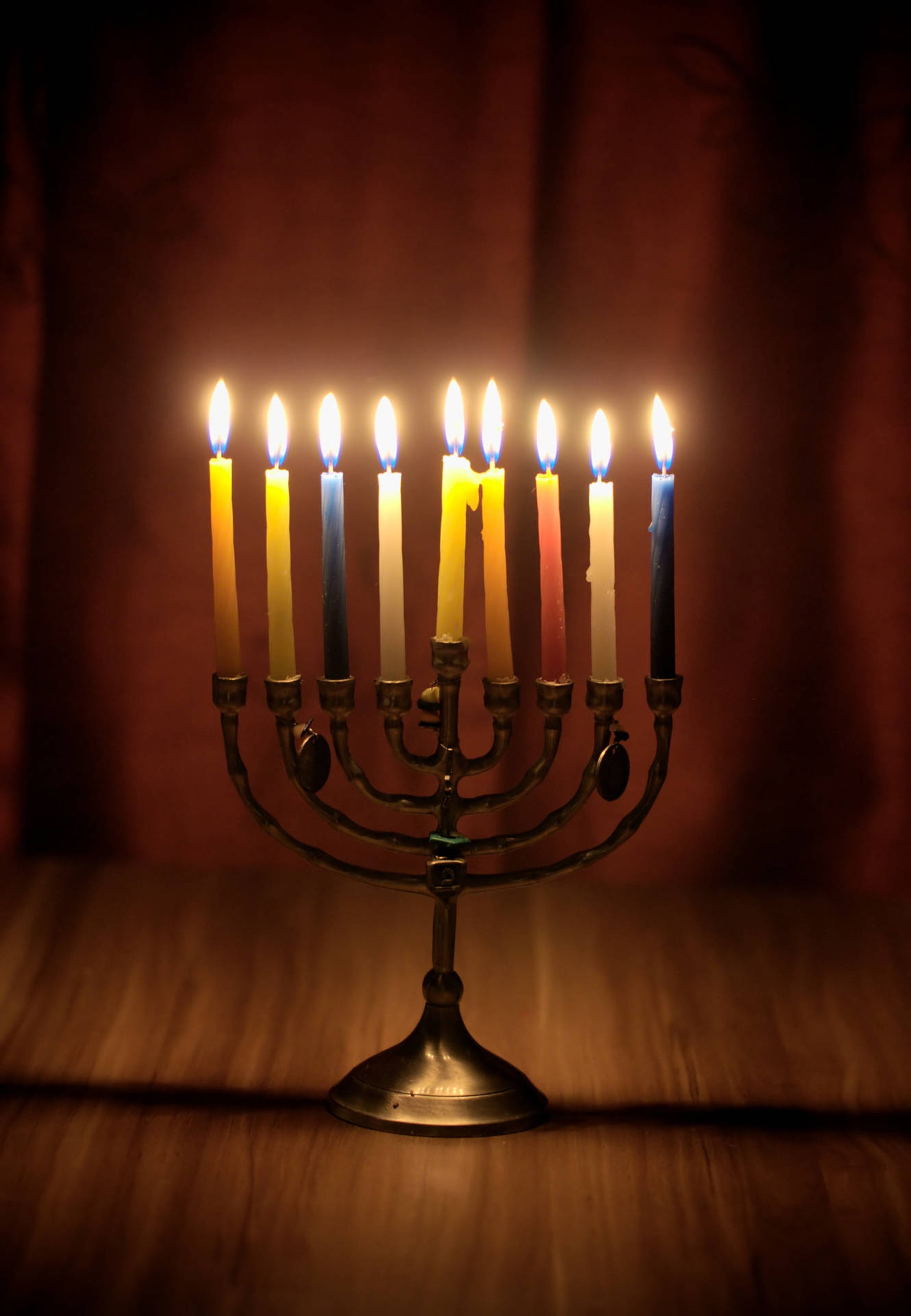 九支點燃的蠟燭在 menorah 上，於木質表面溫暖地發光。 — 光明節 GIF 壁紙
