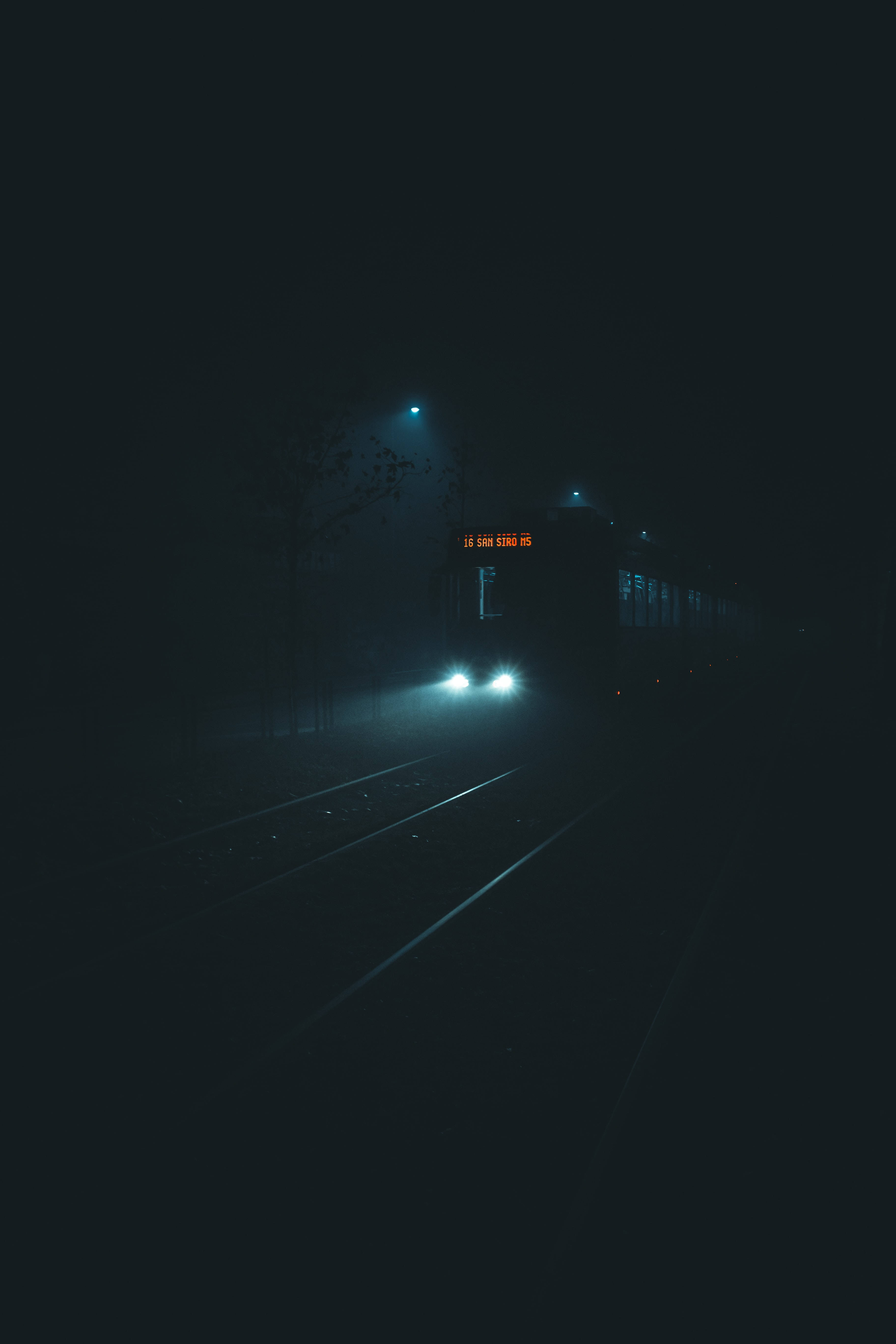 火車 桌布 壁紙 — 一列帶有發光頭燈的火車在無星的夜空下，穿過黑暗軌道上的濃霧。