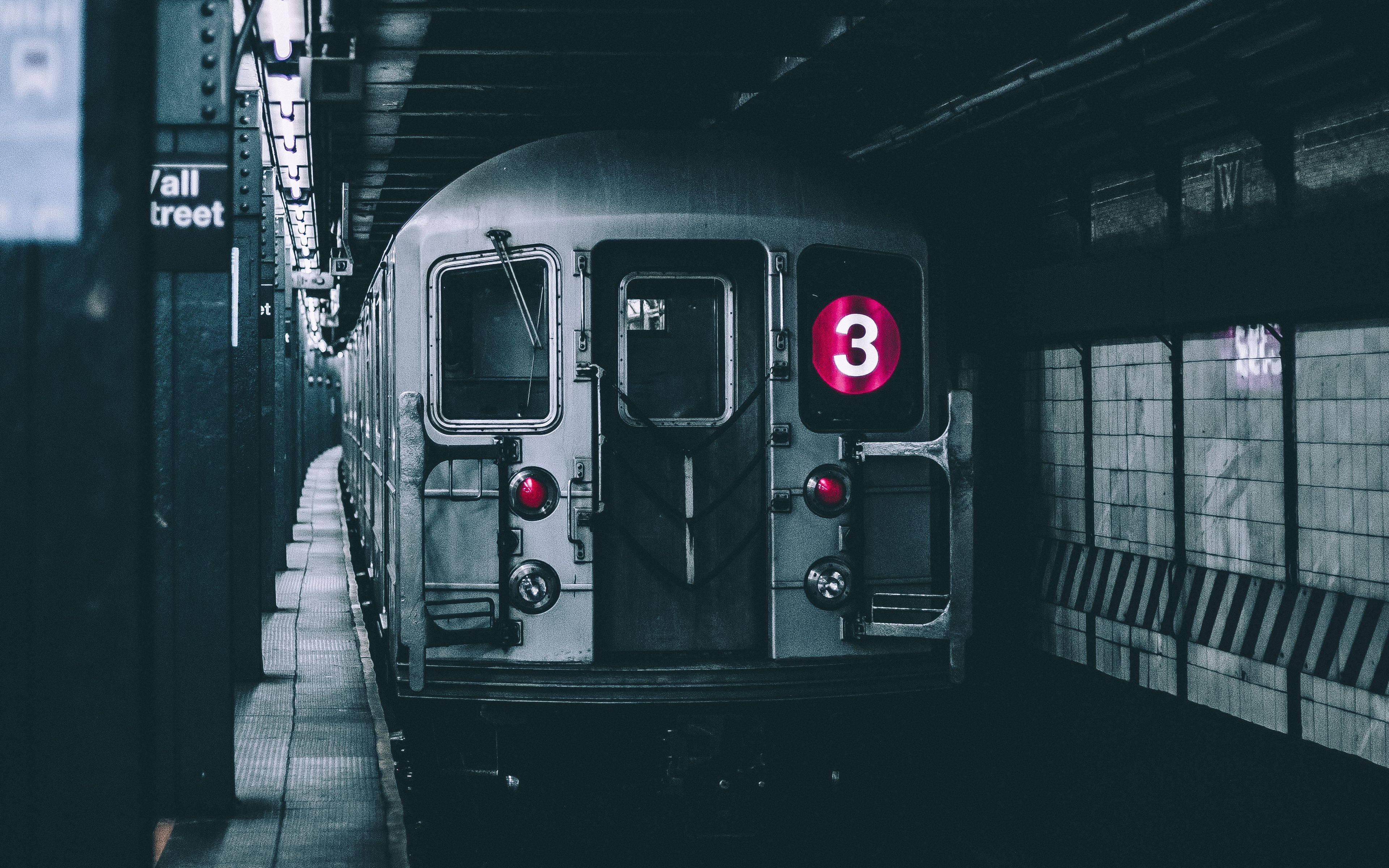 New York 桌布 壁紙 — 一列復古地鐵列車帶有發光的粉紅色三號標誌，停靠在燈光昏暗的地下車站月台上。