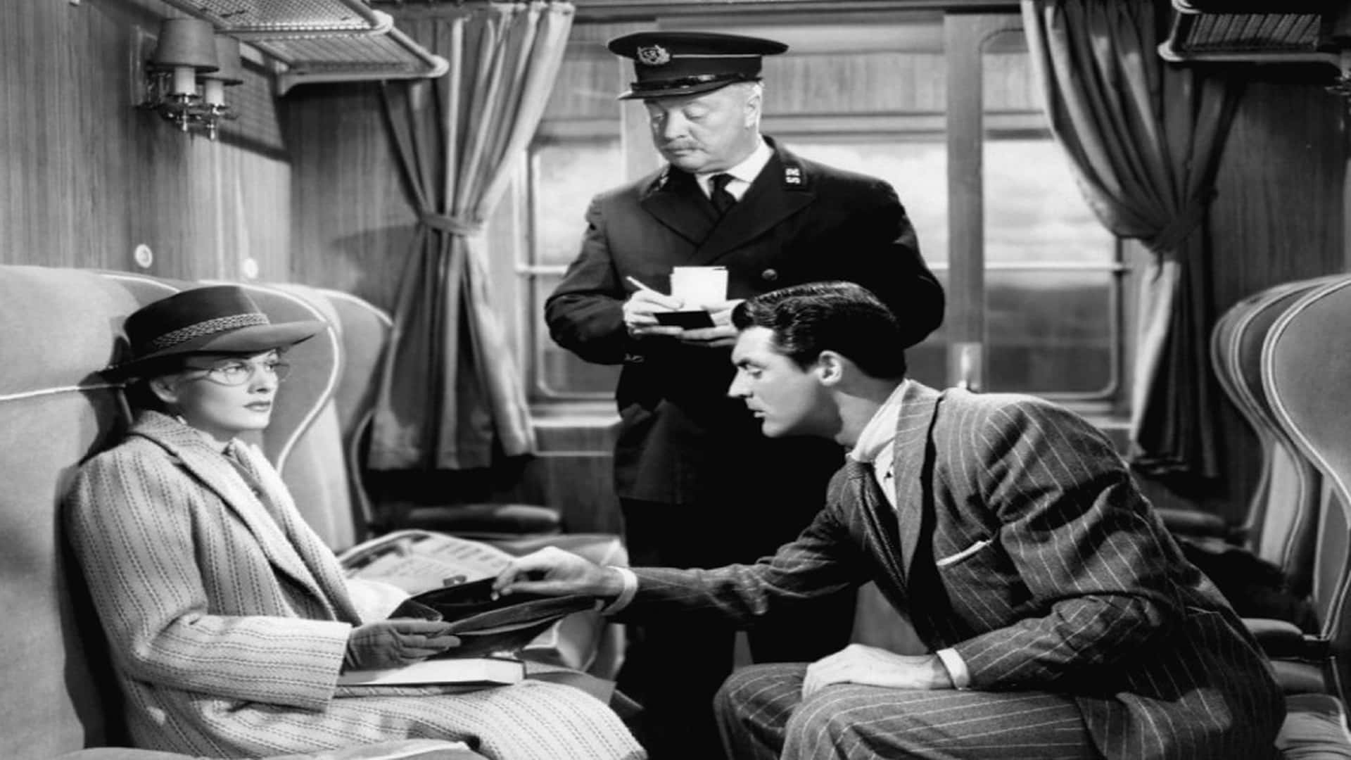 Classic Movie 桌布 壁紙 — 一列復古火車車廂內的黑白場景，一名身穿制服的列車長站在一位戴帽子的坐著女士和一位拿著公事包、身穿細條紋西裝的男士之間。