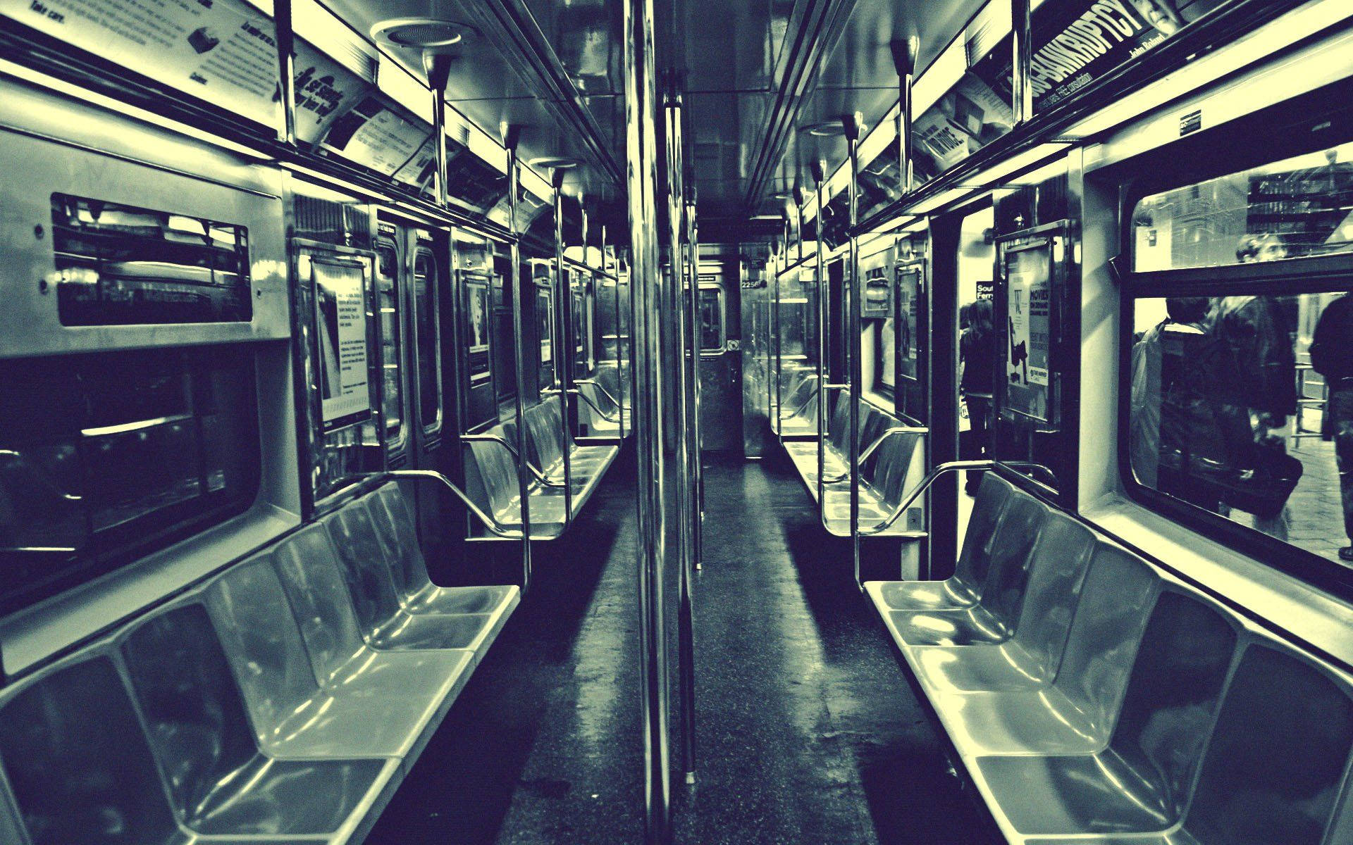 Subway 桌布 壁紙 — 一列長長的空地鐵車廂，配備金屬座椅和反光窗戶，在冷藍色燈光下。