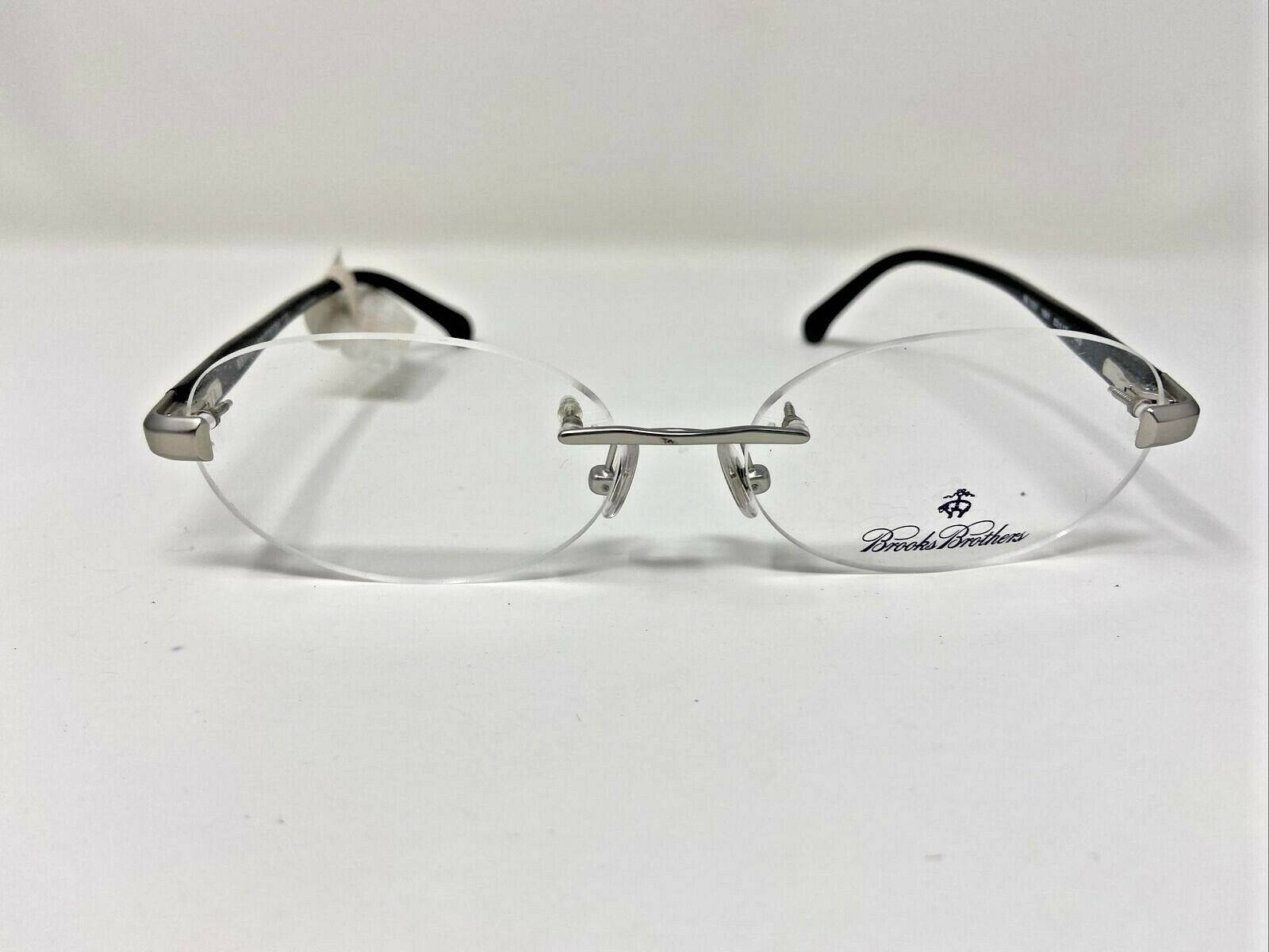 glasses 桌布 壁紙 — 一副Brooks Brothers無框眼鏡，帶有銀色金屬鼻橋和黑色鏡腿，放置在純白色表面上。