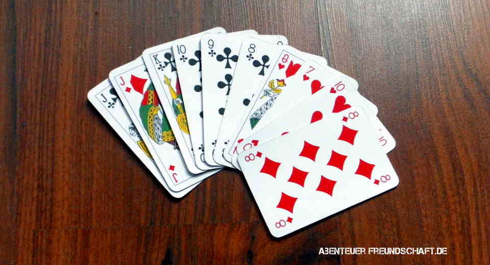 Playing Cards 桌布 壁紙 — 一副攤開成扇形的撲克牌放在深色木紋桌上。