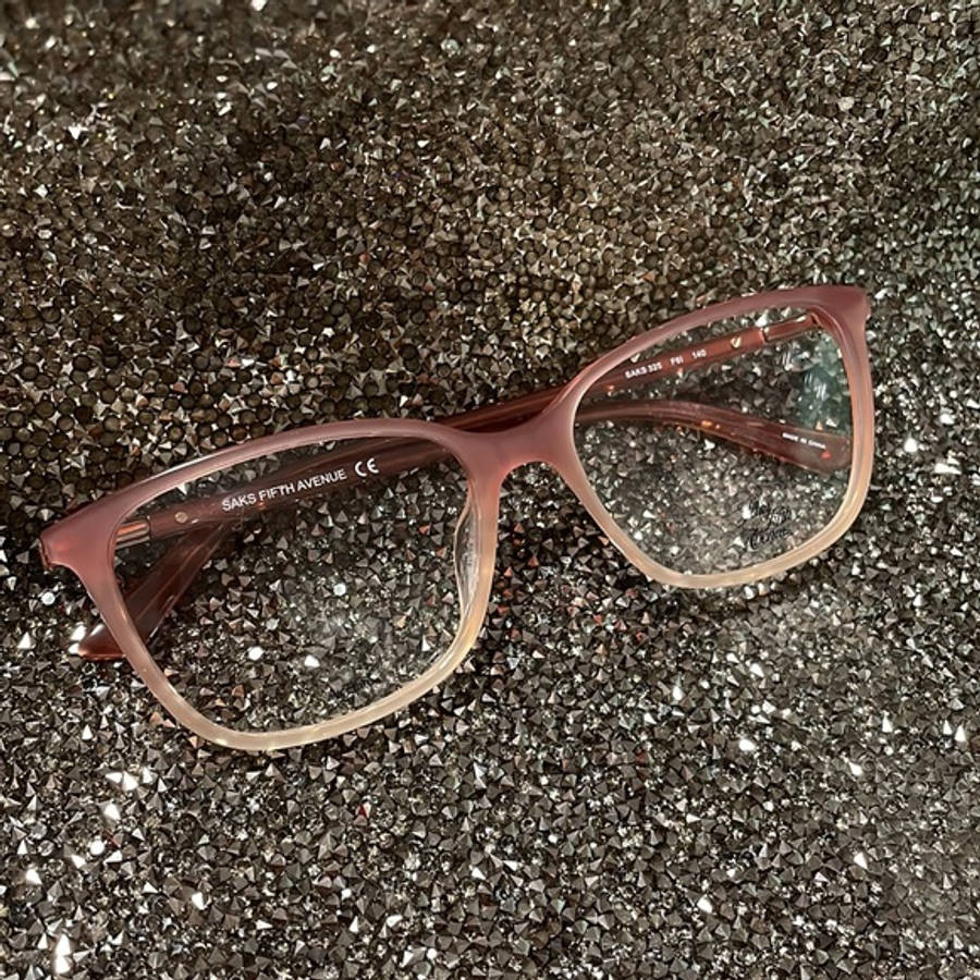 glasses 桌布 壁紙 — 一副玫瑰色Saks Fifth Avenue眼鏡放在閃閃發光的深灰色碎石表面上。