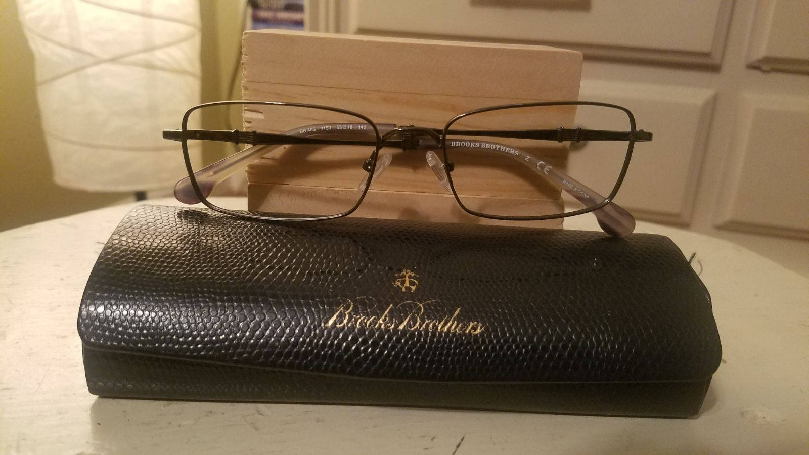 glasses 桌布 壁紙 — 一副黑色鏡框的Brooks Brothers眼鏡放在其紋理黑色眼鏡盒上，置於白色桌子上。