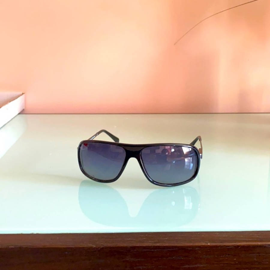 Sunglasses 桌布 壁紙 — 一副黑色飛行員太陽眼鏡放在光滑的白色表面上，背景是柔和的桃色牆壁。