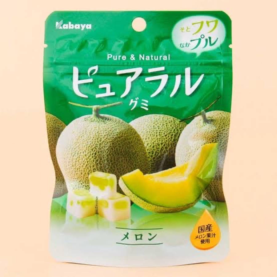 Fruit 桌布 壁紙 — 一包充滿活力的綠色日本哈密瓜口味軟糖，包含完整和切片的哈密瓜以及半透明的糖果片。