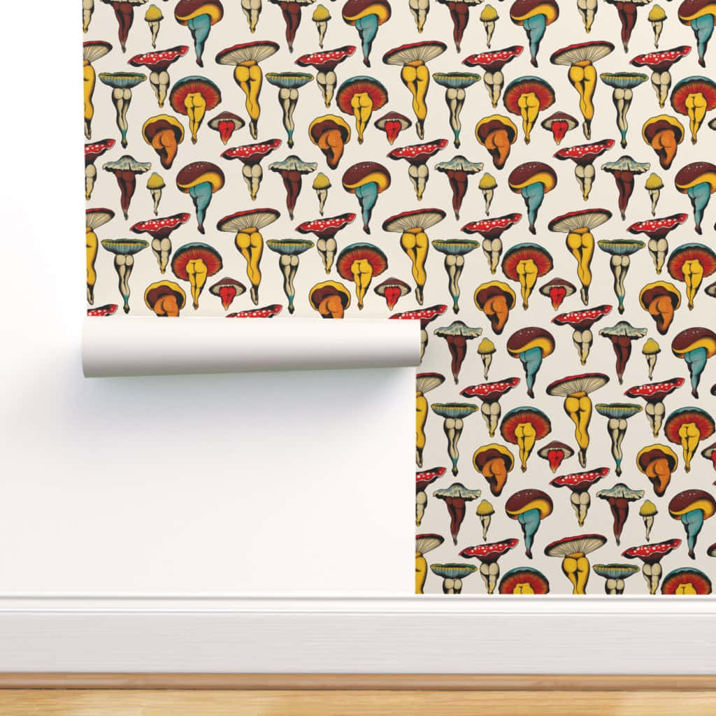 Mushroom Art 桌布 壁紙 — 一卷帶有奇幻蘑菇圖案的壁紙，上面有鮮豔的紅色、黃色和藍綠色菌蓋，正被展開在一面白牆上。