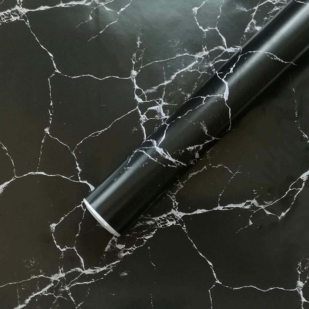 Black Marble 桌布 壁紙 — 一卷黑色大理石紋壁紙斜放在帶有白色紋理的黑色大理石表面上。