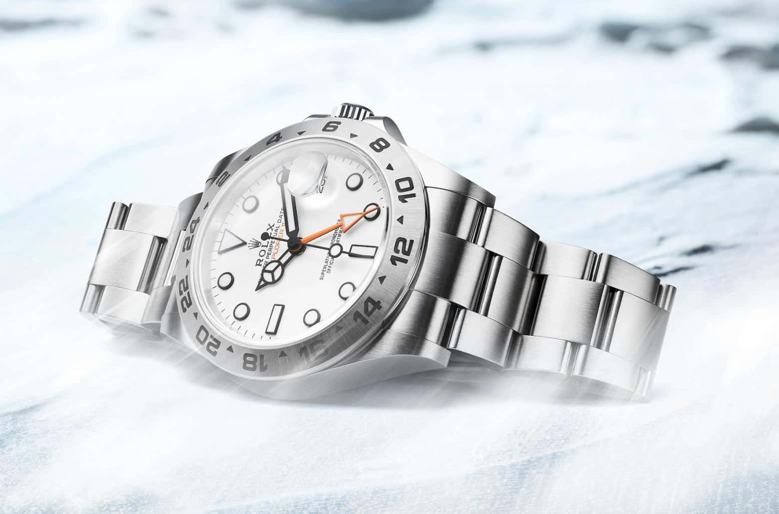 Rolex 桌布 壁紙 — 一只時尚的銀色勞力士手錶放在雪白和藍色調的雪地上。