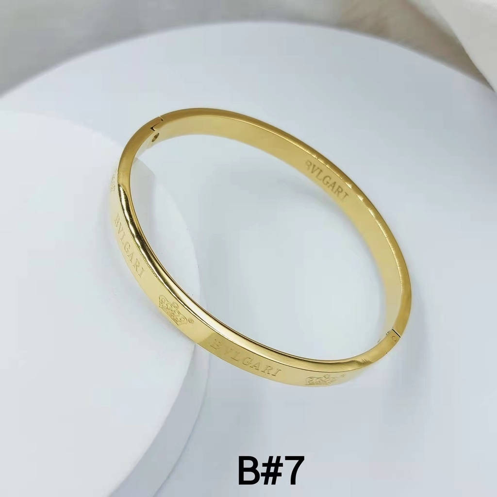 品牌 桌布 壁紙 — 一只時尚的黃金Bulgari手鐲優雅地放在白色陶瓷表面上，帶有柔和陰影。