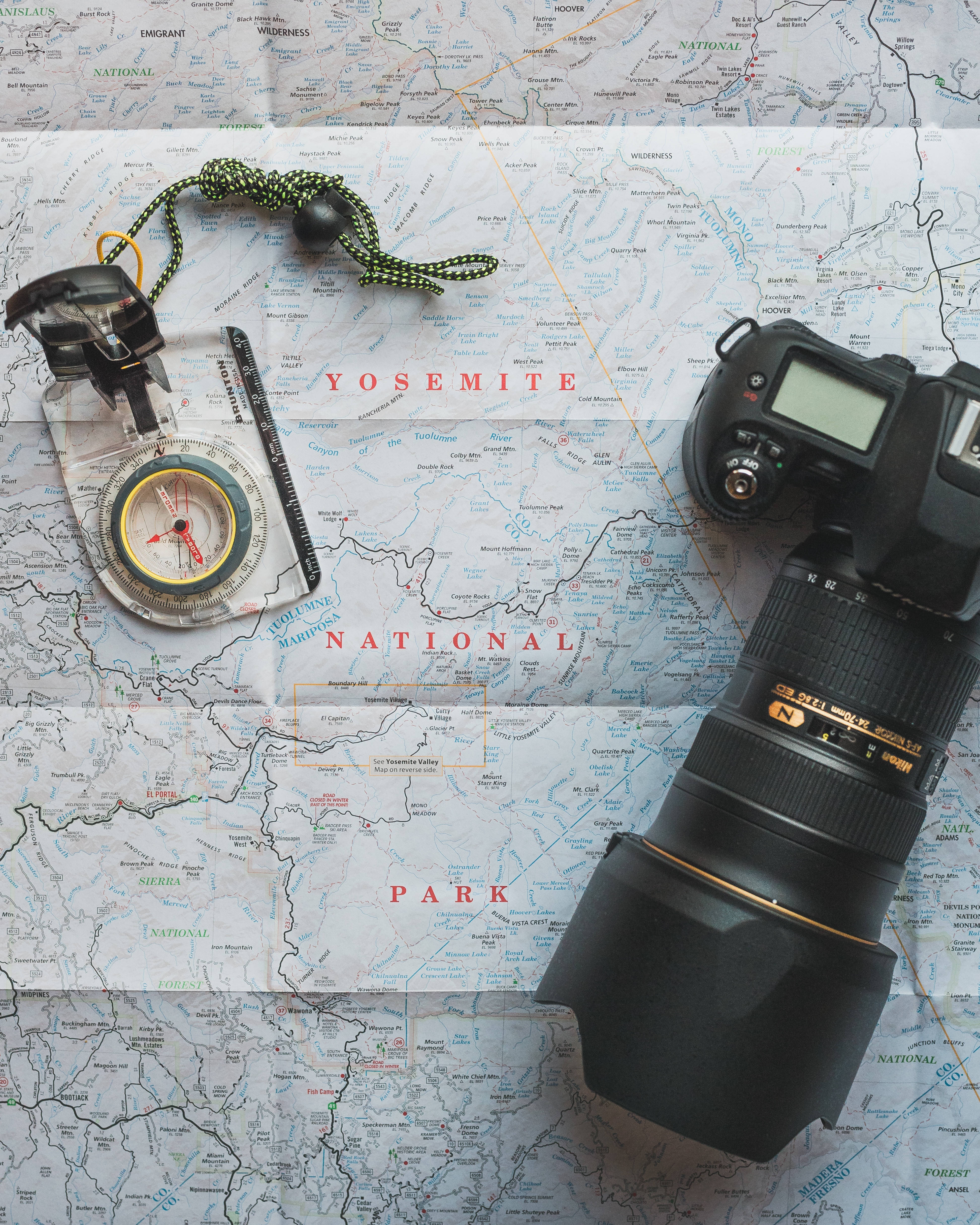 旅行 桌布 壁紙 — 一台 DSLR 相機和指南針放在詳細的優勝美地國家公園地圖上，準備好冒險。