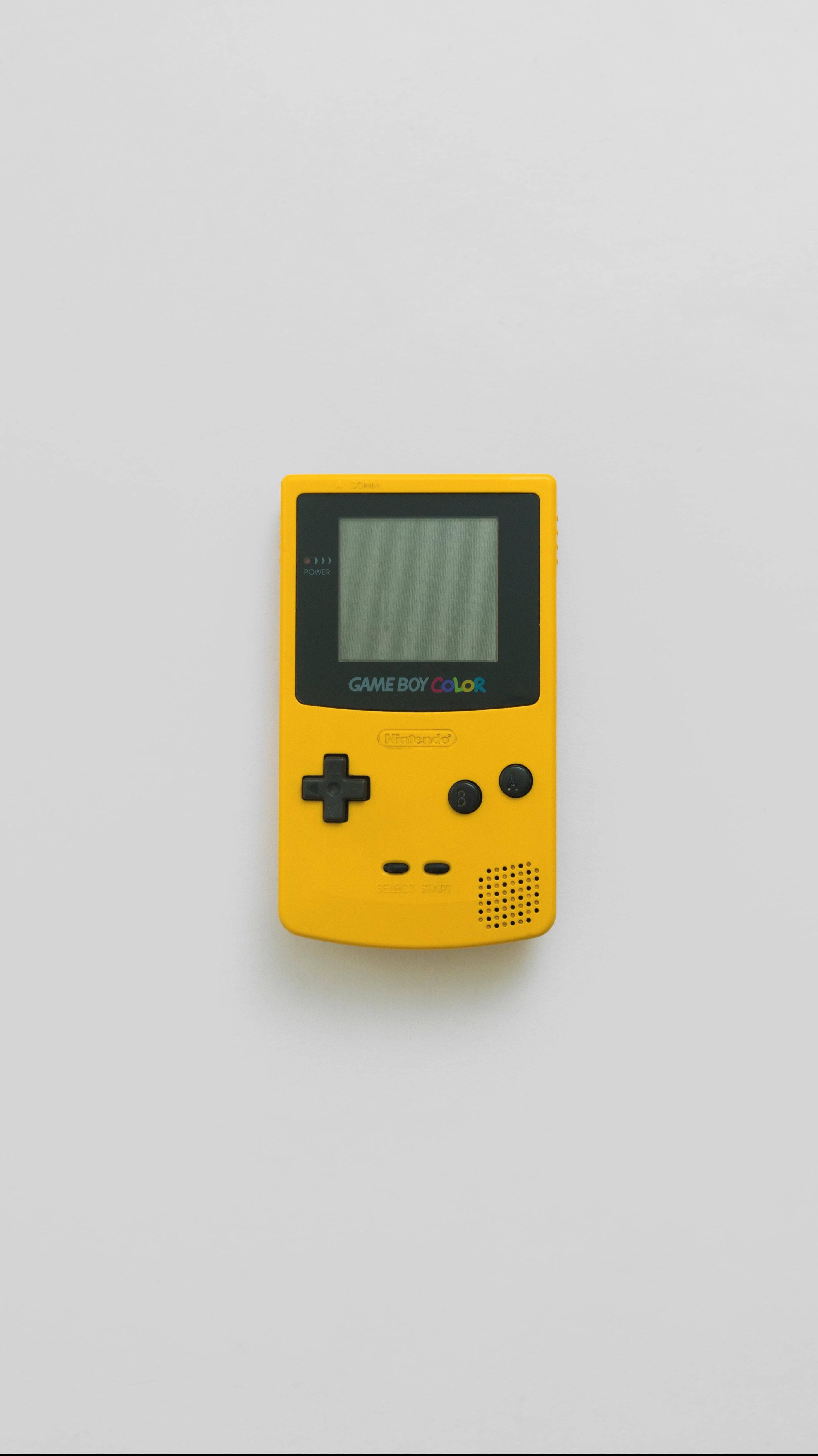 game 桌布 壁紙 — 一台亮黃色的 Game Boy Color 主機置於純白表面中央，光線柔和均勻。