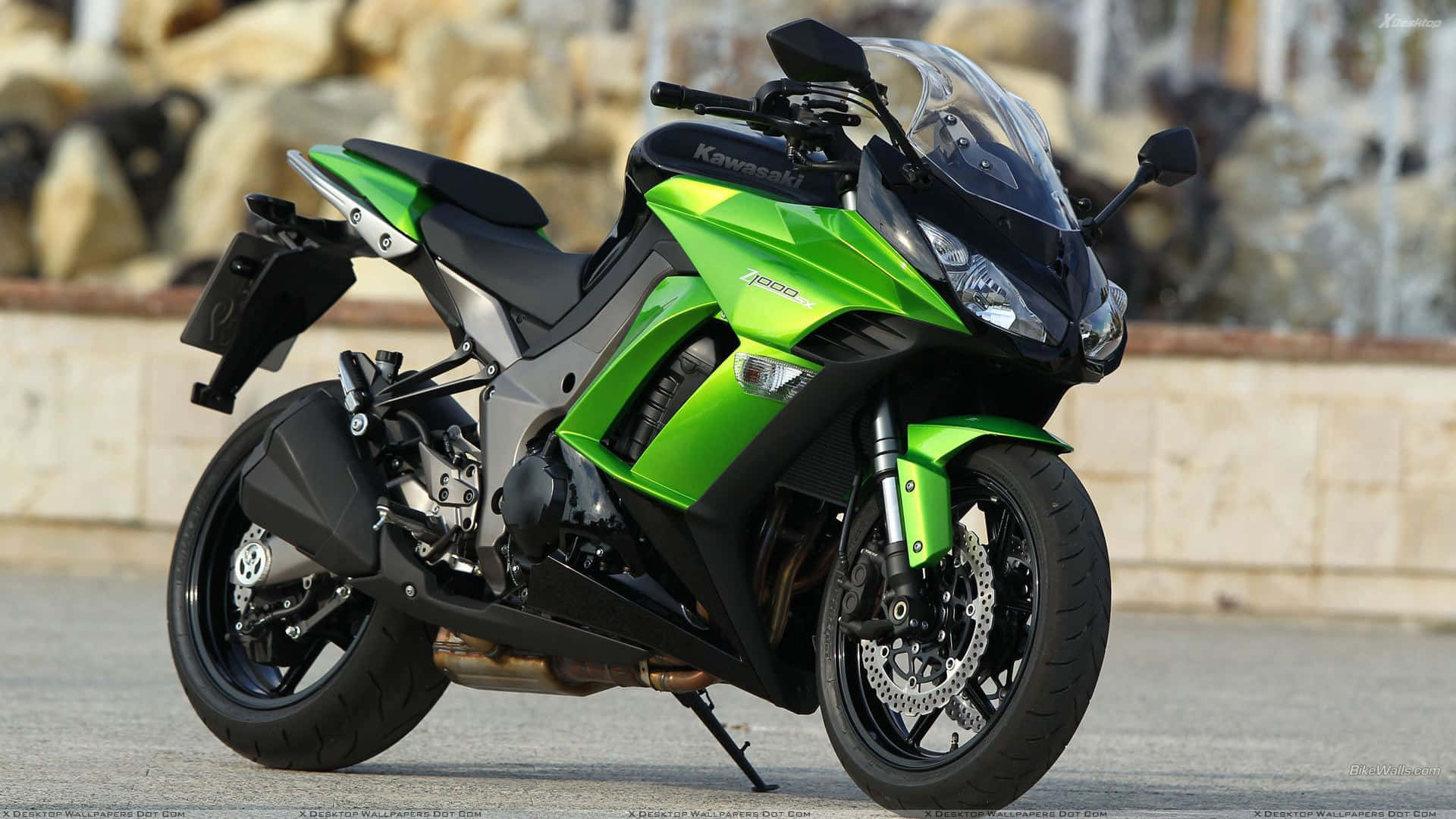 Kawasaki Desktop 桌布 壁紙 — 一台充滿活力的綠色Kawasaki Ninja 400運動機車停在鋪砌的路面上，背景是岩石地形。