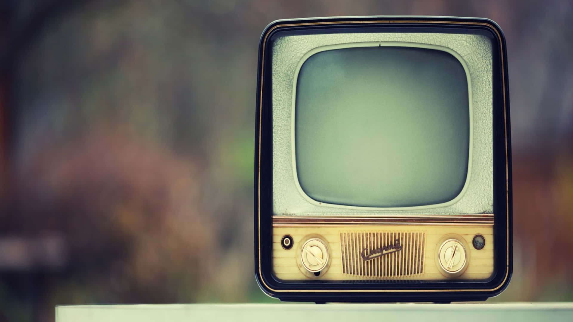 Television Set 桌布 壁紙 — 一台帶有空白螢幕的復古電視機放置在窗台上，背景是柔和模糊的秋日景色。