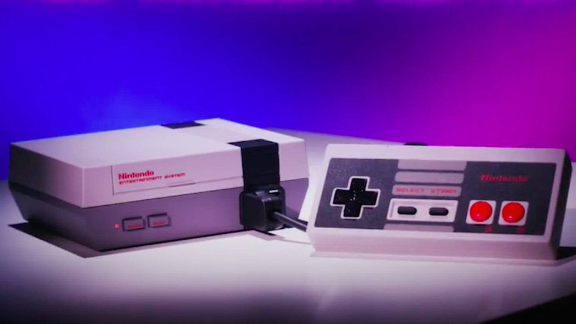 紅白機 桌布 壁紙 — 一台復古的Nintendo Entertainment System主機和控制器在充滿活力的紫色和藍色工作室燈光下發光。