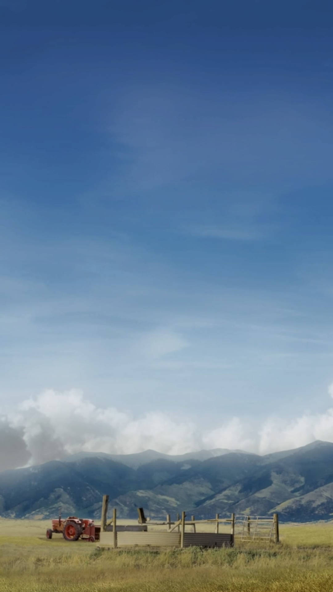 far cry 5 iPhone 桌布 壁紙 — 一台復古紅色拖拉機停在一片金色田野中，背景是遠方的綠色山脈，上方是廣闊的藍天和縷縷白雲。