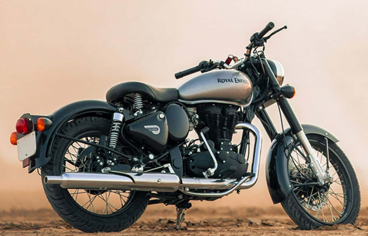 機車 桌布 壁紙 — 一台時尚的 Royal Enfield 摩托車在塵土飛揚的地形上，於朦朧天空下，沐浴在溫暖環境光中。