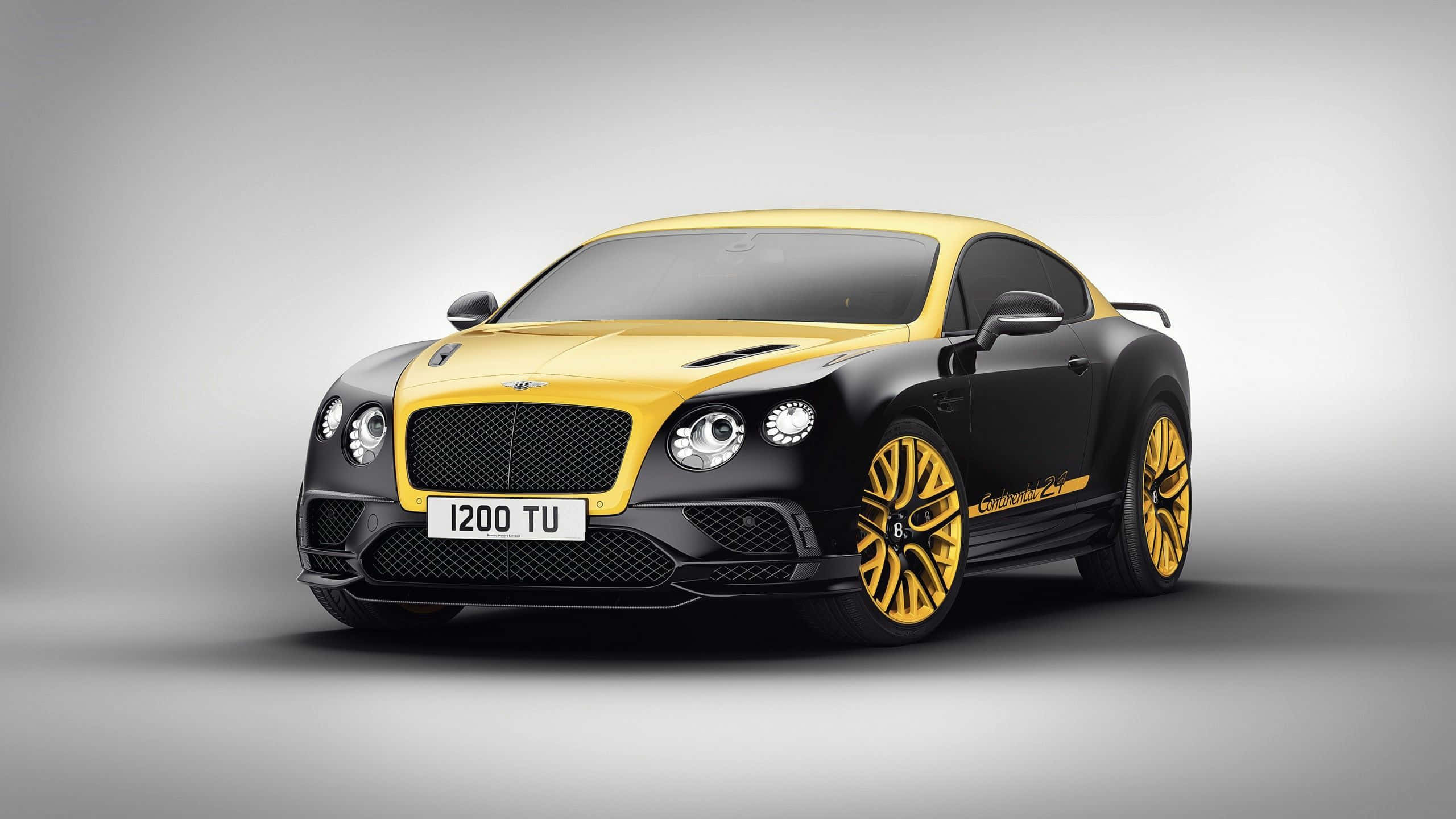 賓利 桌布 壁紙 — 一台時尚的Bentley Continental Supersports，帶有醒目的黑色和黃色塗裝及金色輪圈，在灰色中性工作室背景前擺姿勢。