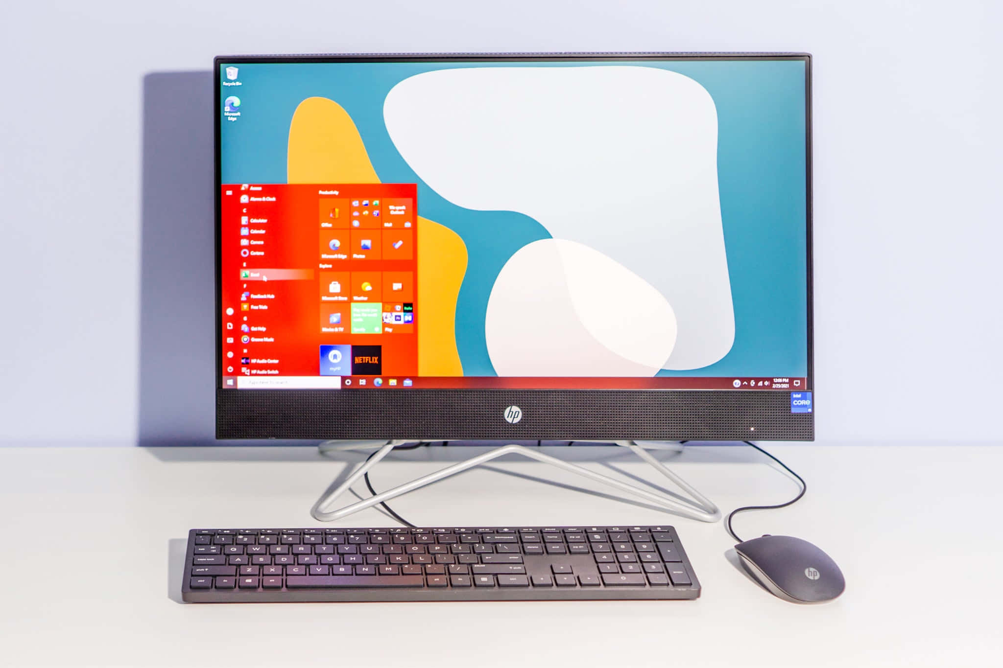 電腦 桌布 壁紙 — 一台時尚的HP一體式桌面電腦，螢幕上顯示著生動的Windows介面，放置在乾淨的白色桌子上，配有鍵盤和滑鼠。