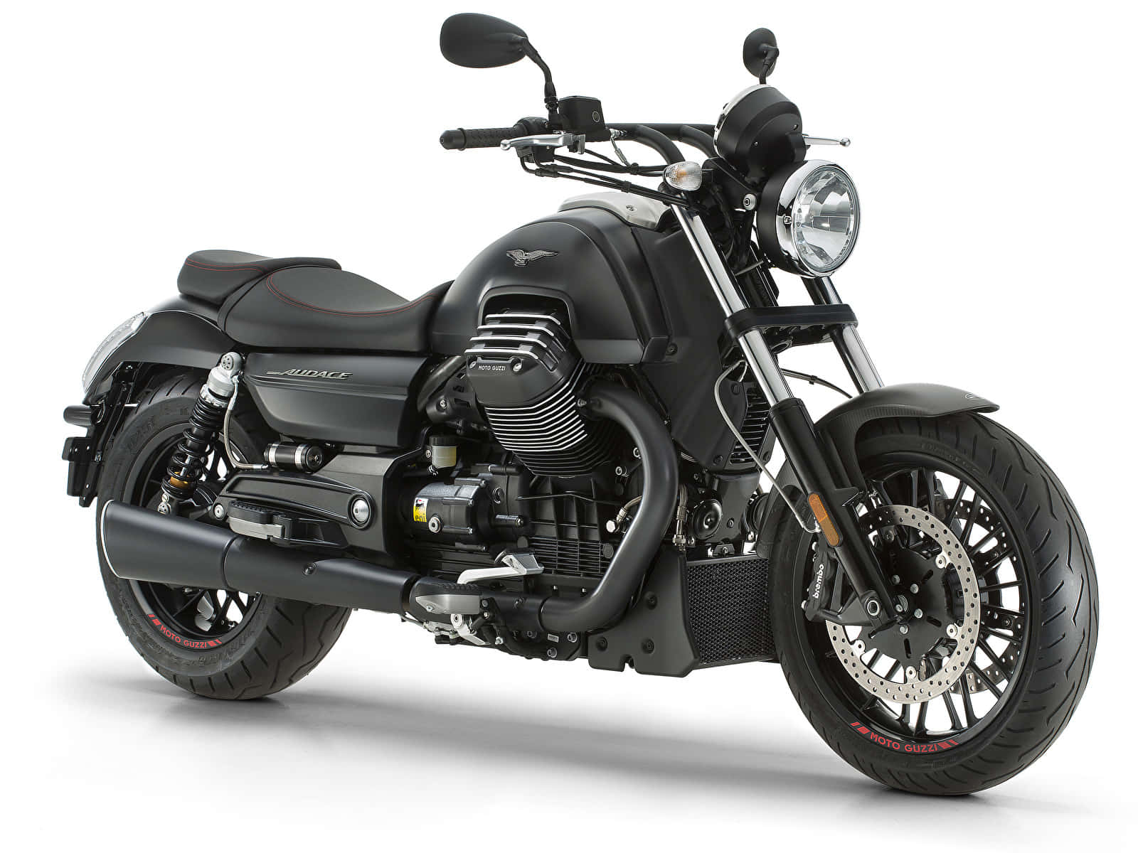 Moto Guzzi 桌布 壁紙 — 一台時尚的啞光黑色機車，帶有鍍鉻裝飾和紅色輪胎細節，在純白背景前蓄勢待發。