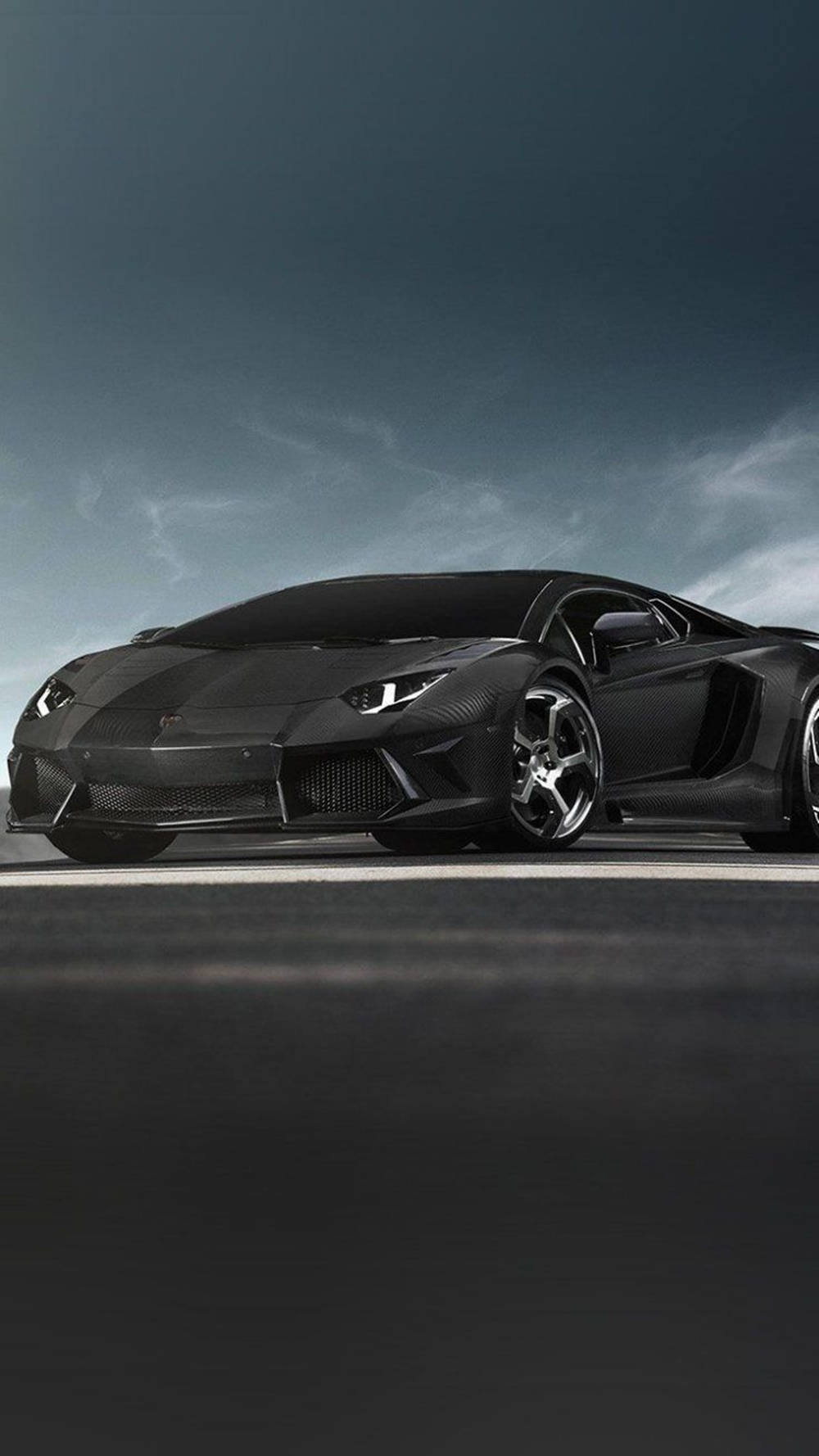 黑色 桌布 壁紙 — 一台時尚的啞光黑色藍寶堅尼 Aventador 在暮色沉沉的天空下，靜止在黑暗的道路上。
