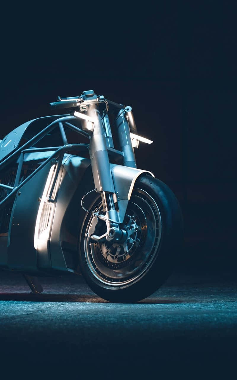 Electric Bike 桌布 壁紙 — 一台時尚的未來感機車，帶有外露車架和發光藍色亮點，在黑暗背景下戲劇性地照亮。