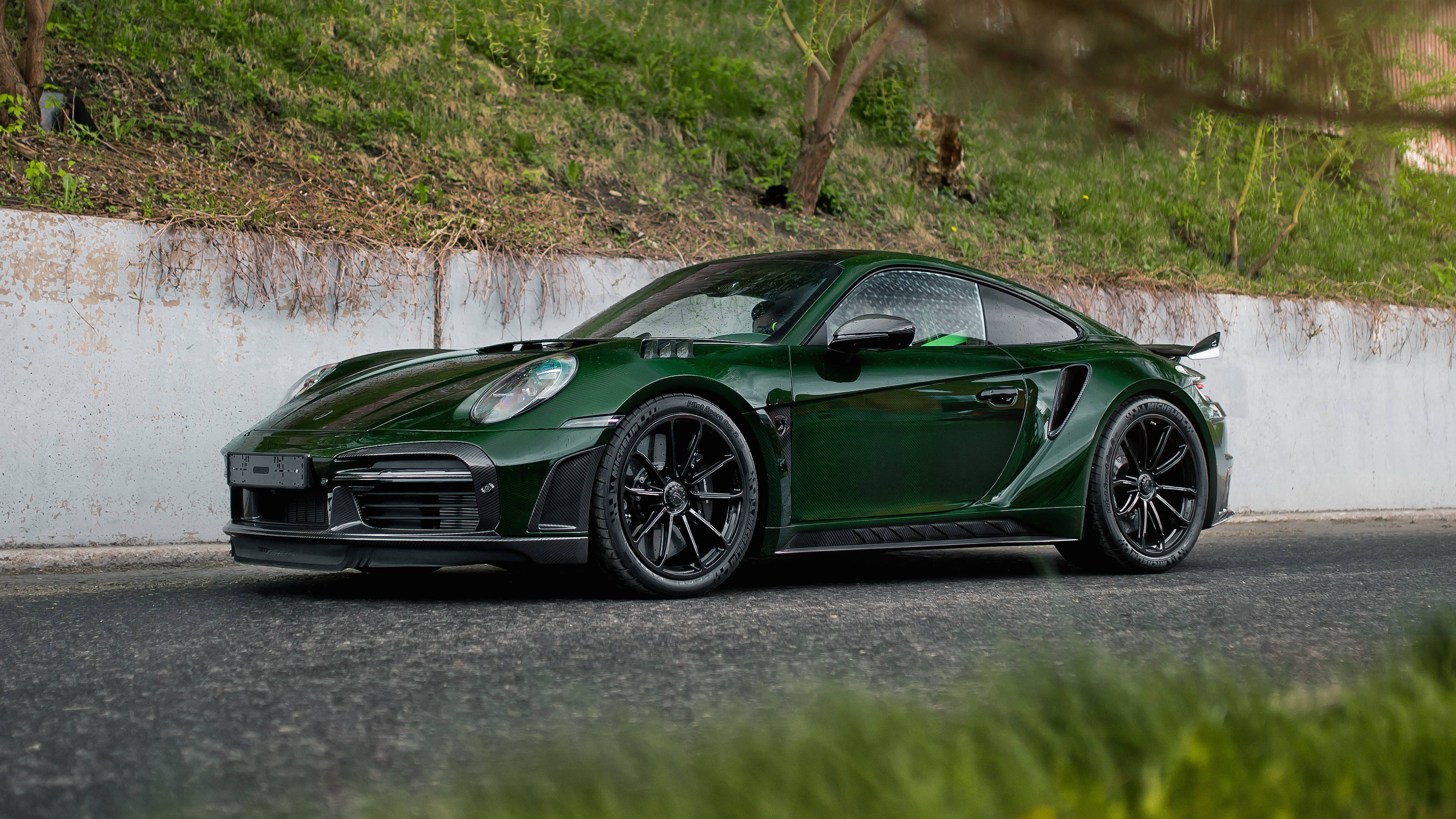 深綠色保時捷911 GT2 RS停泊在草地斜坡附近的路邊。 — 保時捷 GIF 壁紙