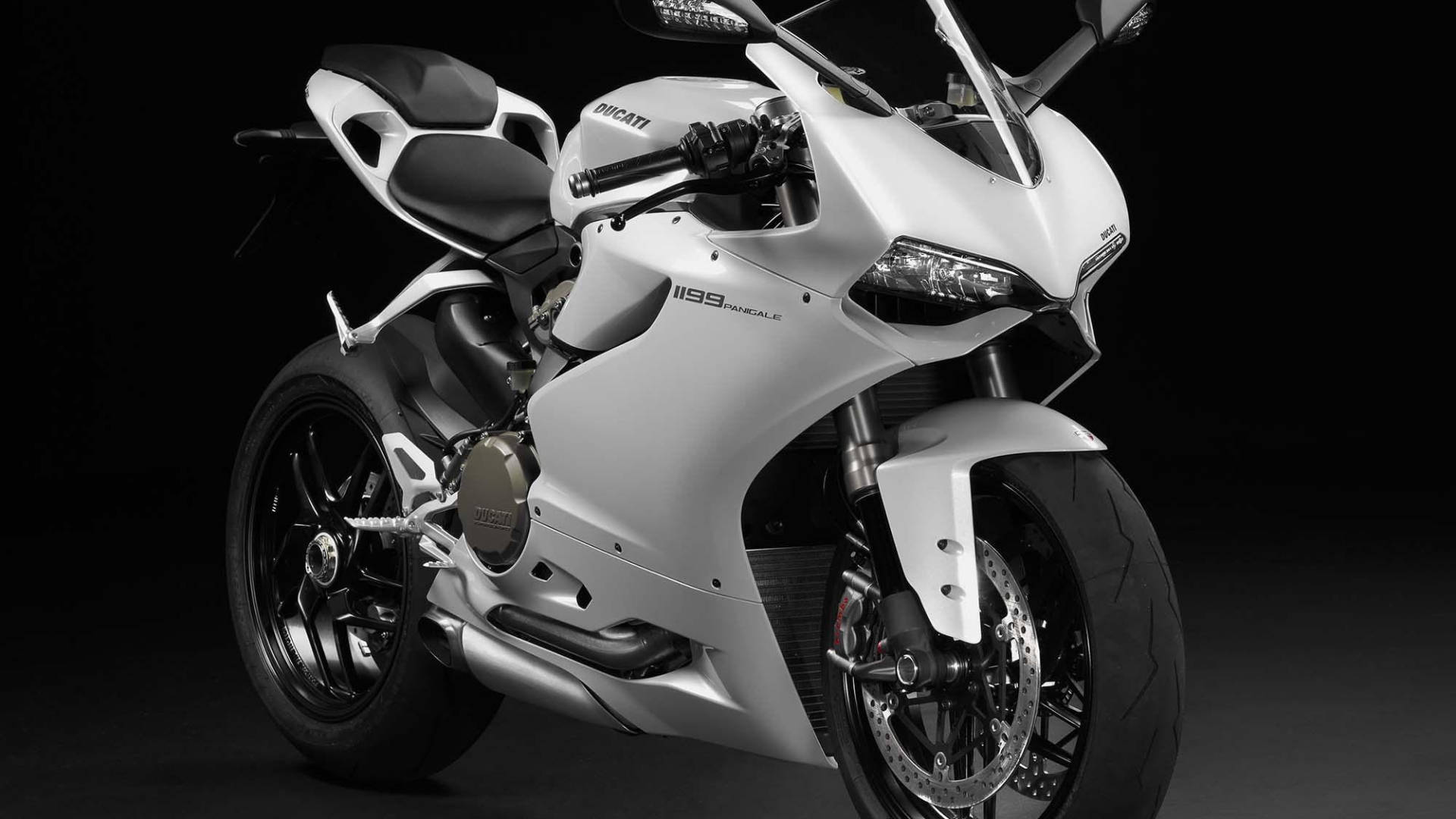 杜卡迪 桌布 壁紙 — 一台時尚的白色Ducati 1199 Panigale摩托車，帶有黑色點綴和銀色排氣管，在黑暗的攝影棚背景下蓄勢待發。