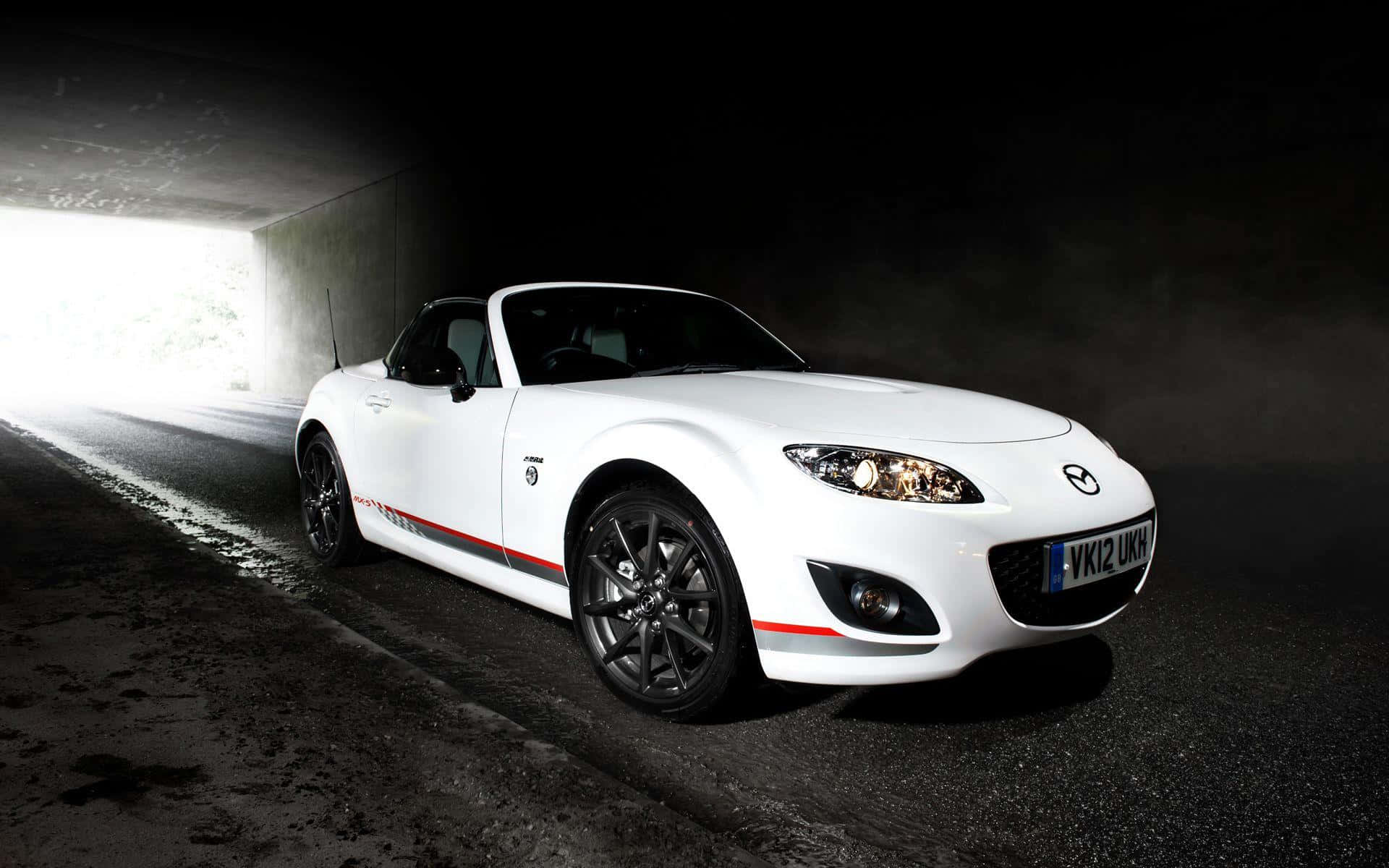 Miata 桌布 壁紙 — 一台時尚的白色Mazda MX-5敞篷跑車從黑暗的隧道中駛出，背後有明亮的光線湧入。
