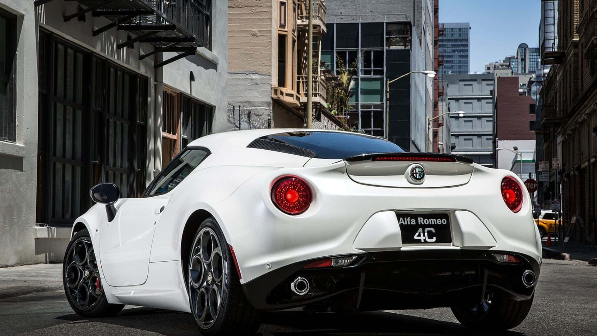 Alfa Romeo 4c 桌布 壁紙 — 一台時尚的白色愛快羅密歐4C跑車停放在陽光明媚的城市街道上，背景是高樓大廈和防火梯。