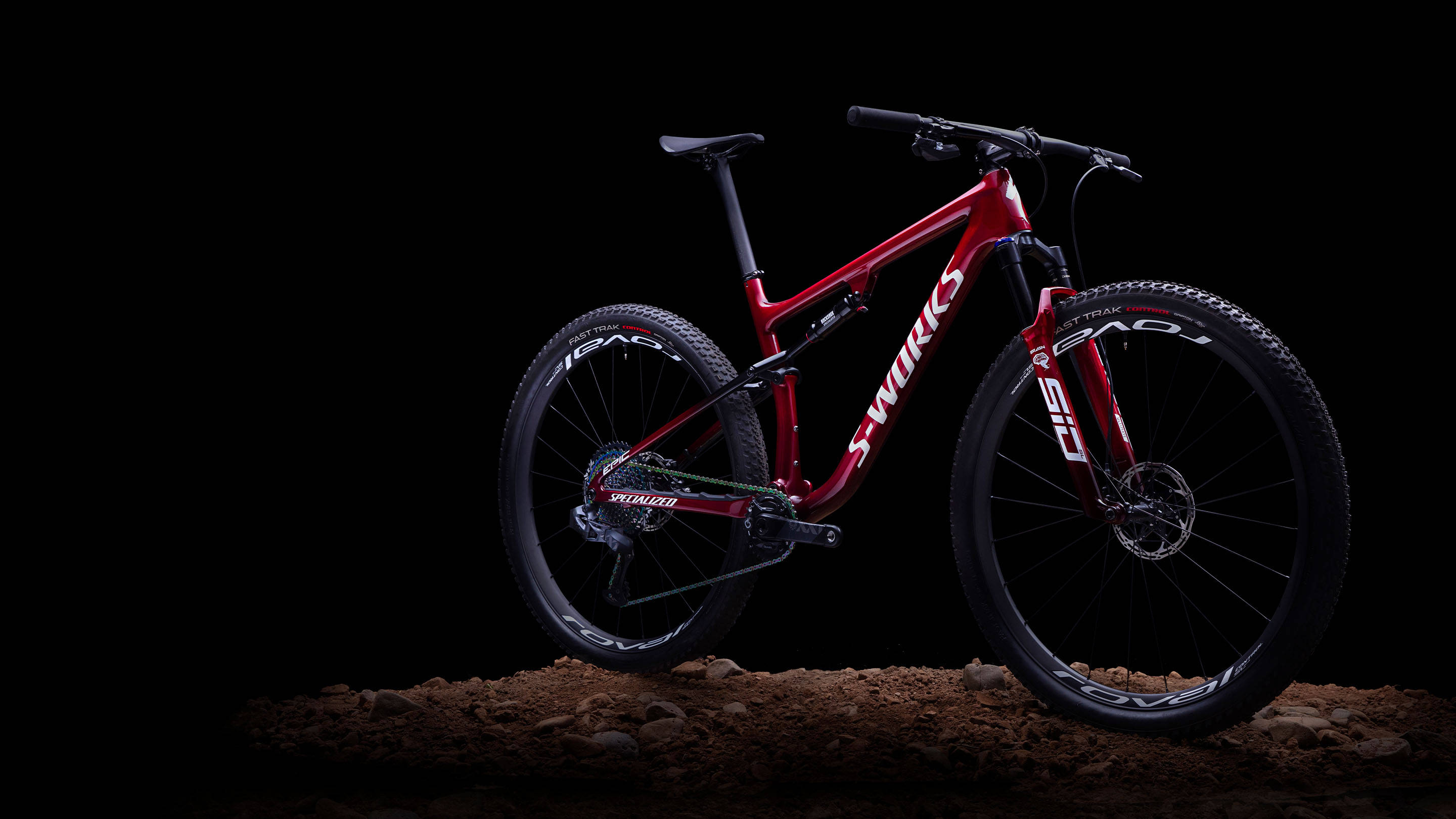 腳踏車 桌布 壁紙 — 一台時尚的紅色Specialized S-Works登山車在黑色背景的崎嶇泥土上蓄勢待發。