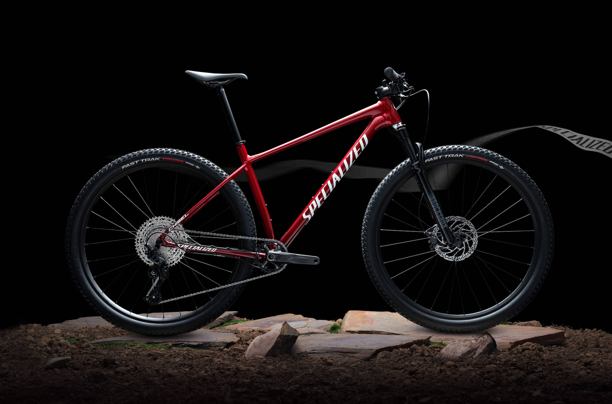 腳踏車 桌布 壁紙 — 一台時尚的紅色Specialized登山自行車在崎嶇地形上，以黑色背景襯托。