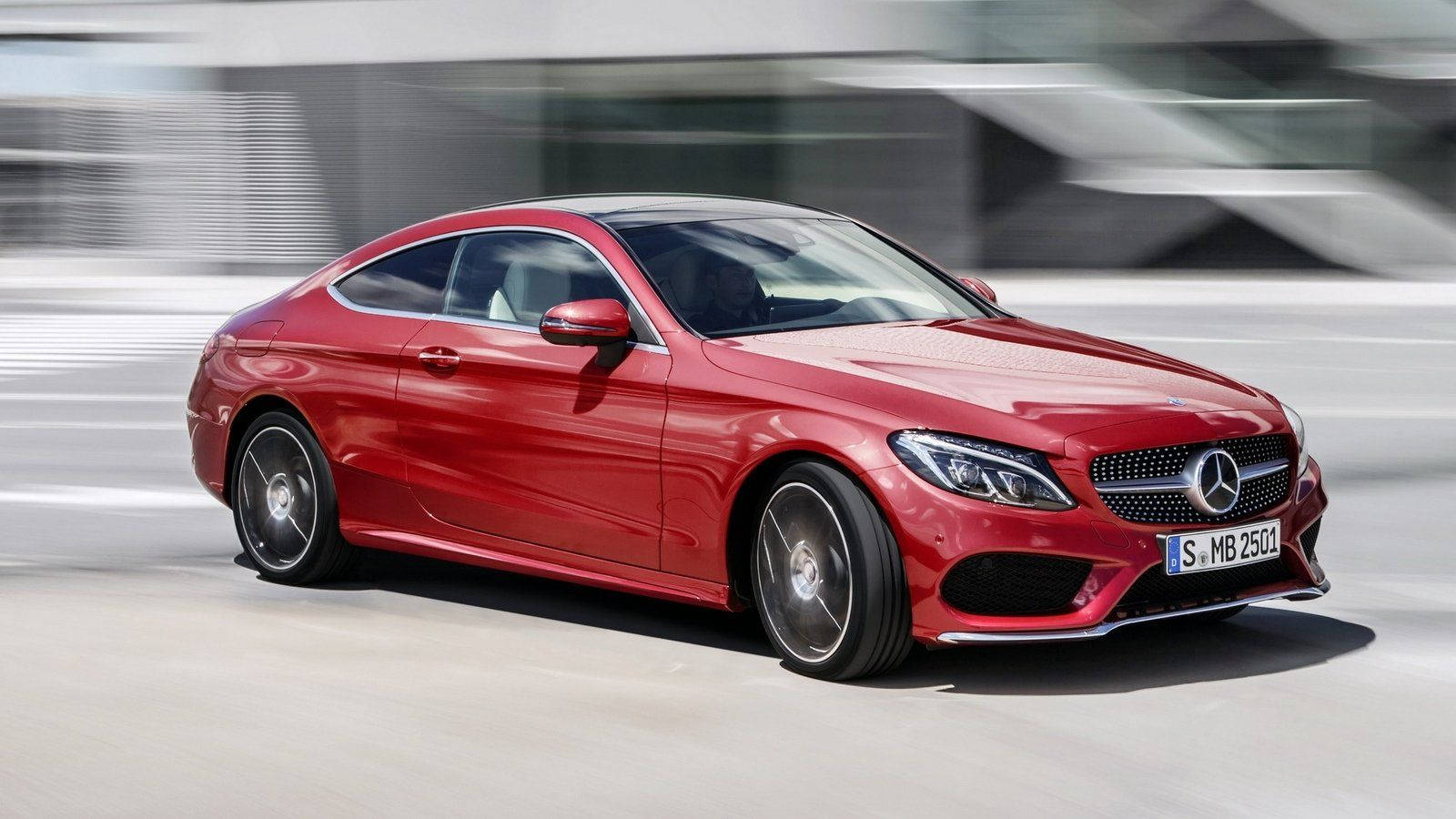 Mercedes Benz C300 桌布 壁紙 — 一台時尚的紅色賓士C-Class轎跑車在現代都市環境中疾馳，動態模糊效果凸顯其動感。