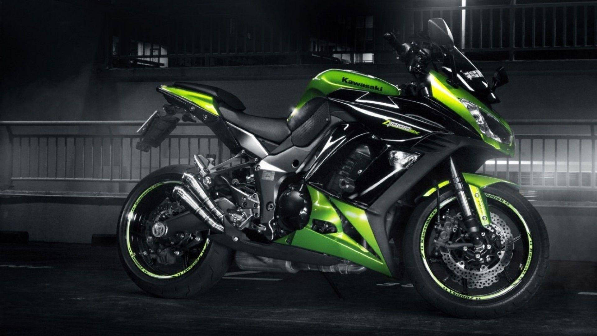 Cool Bike 桌布 壁紙 — 一台時尚的綠色和黑色Kawasaki運動機車在黑暗的城市車庫中，在戲劇性的工作室燈光下閃閃發光。