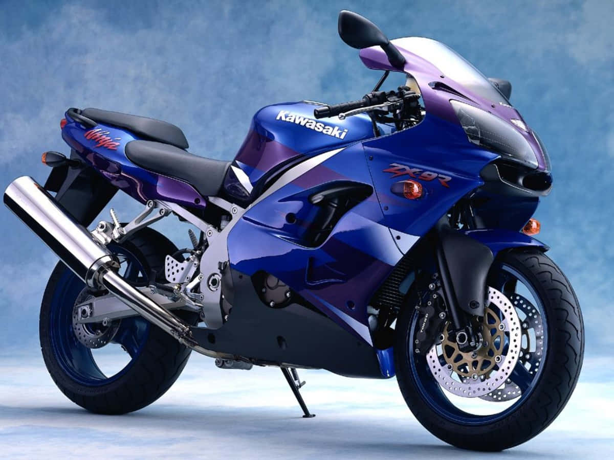 腳踏車 桌布 壁紙 — 一台時尚的藍紫色川崎ZX-9R運動摩托車，擺放在柔和的漸變藍色工作室背景前。